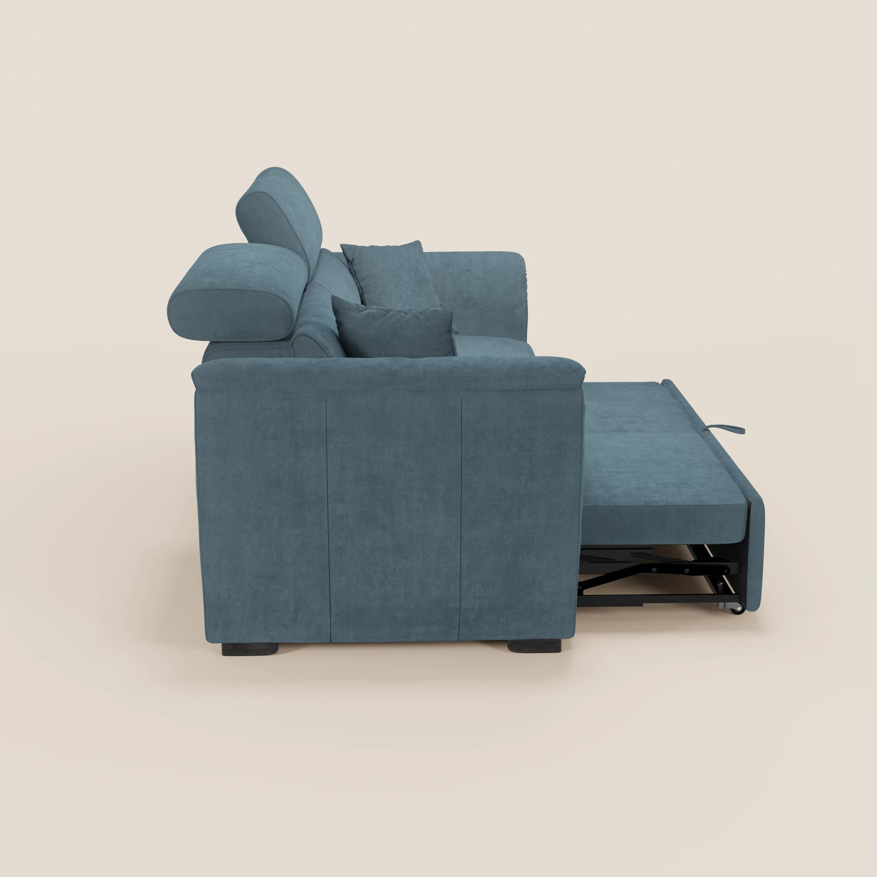 Il divano a 2 posti estraibile Titano con poggiatesta reclinabili in tessuto smacchiabile Oeko-Tex® di Divani.Store è raffigurato di profilo con il letto estraibile parzialmente aperto e due cuscini coordinati su uno sfondo beige chiaro.