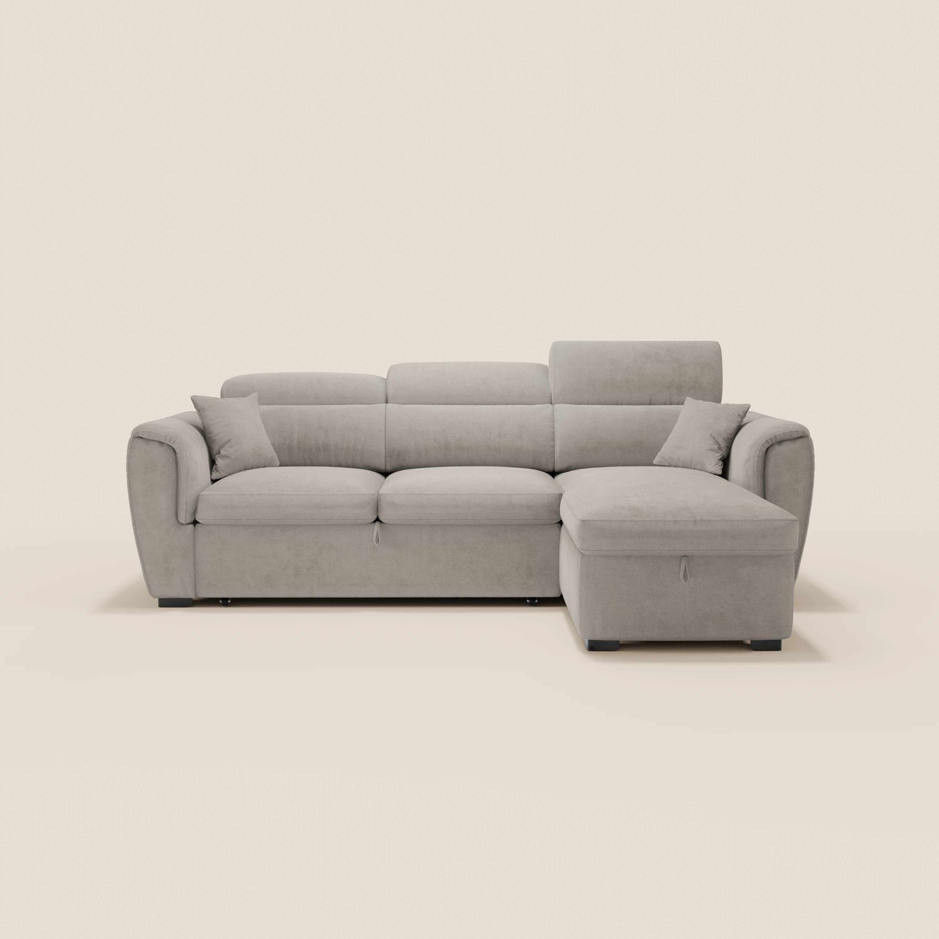 Il divano letto Titano di Divani.Store è un divano moderno di colore grigio chiaro, dotato di chaise longue reversibile, poggiatesta reclinabili, elemento estraibile, vano contenitore e tessuto antimacchia; nella foto è raffigurato con due cuscini su uno sfondo bianco sporco.