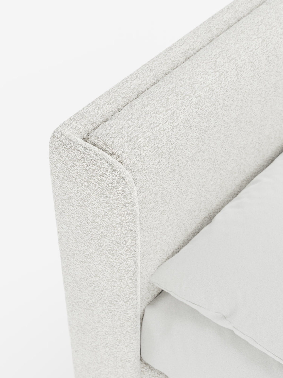 Primo piano del letto di design VALKIRIA con contenitore e testiera avvolgente di Letti.store, caratterizzato da un tessuto Oeko-Tex® dalla trama leggera e da bordi morbidi e arrotondati della testiera, con due soffici cuscini imbottiti. Sul materasso sono parzialmente visibili un cuscino bianco e un lenzuolo disposti con cura, che mettono in risalto il design contemporaneo di questo elegante letto imbottito su uno sfondo luminoso e minimalista.