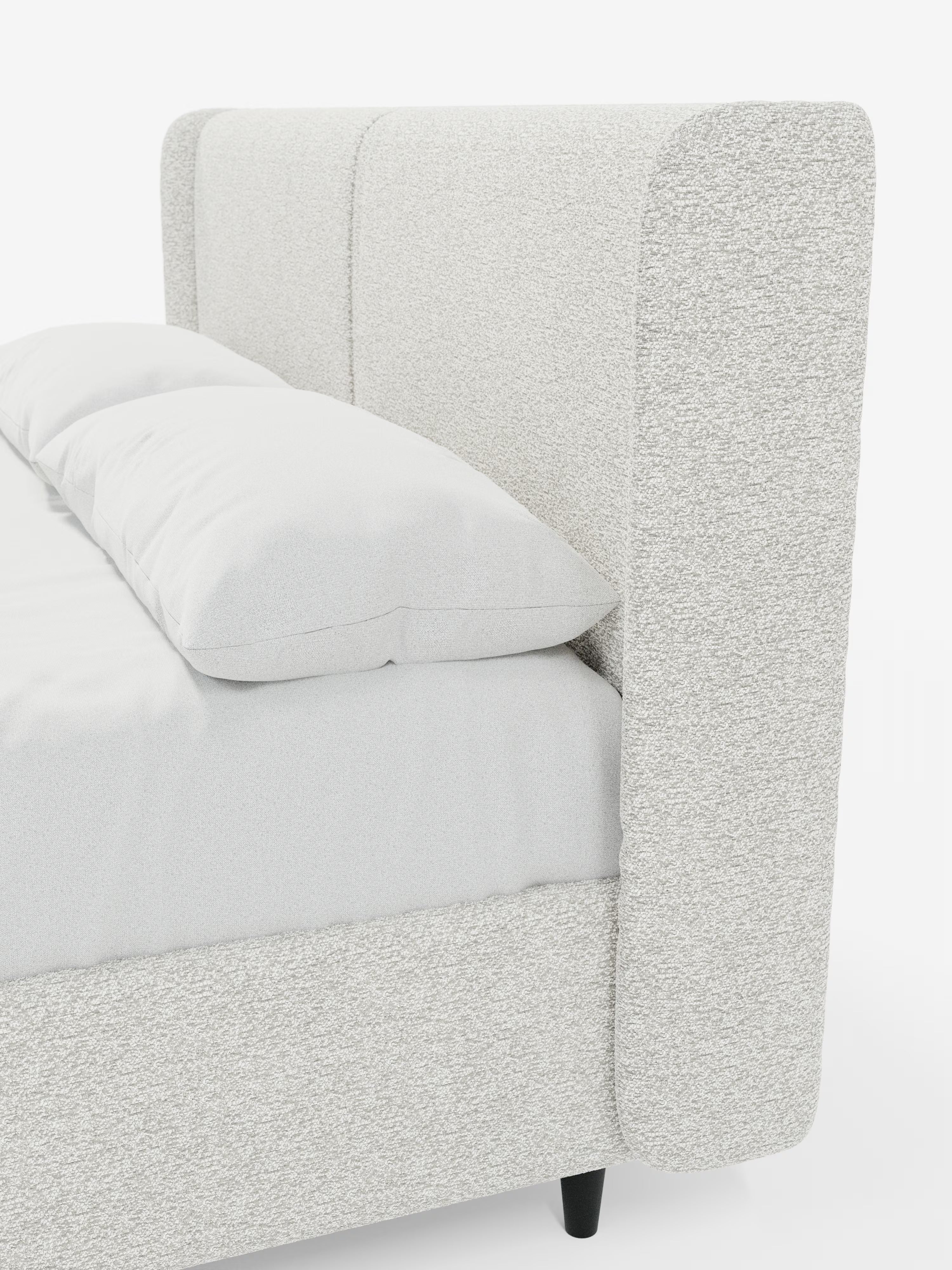 Un primo piano del letto di design VALKIRIA con vano contenitore e testiera avvolgente di Letti.store, caratterizzato da un’alta testiera imbottita di colore grigio chiaro e da pannelli laterali. Questo letto imbottito in stile contemporaneo presenta biancheria da letto bianca, due cuscini imbottiti certificati Oeko-Tex® e gambe corte nere, il tutto su uno sfondo bianco a tinta unita.