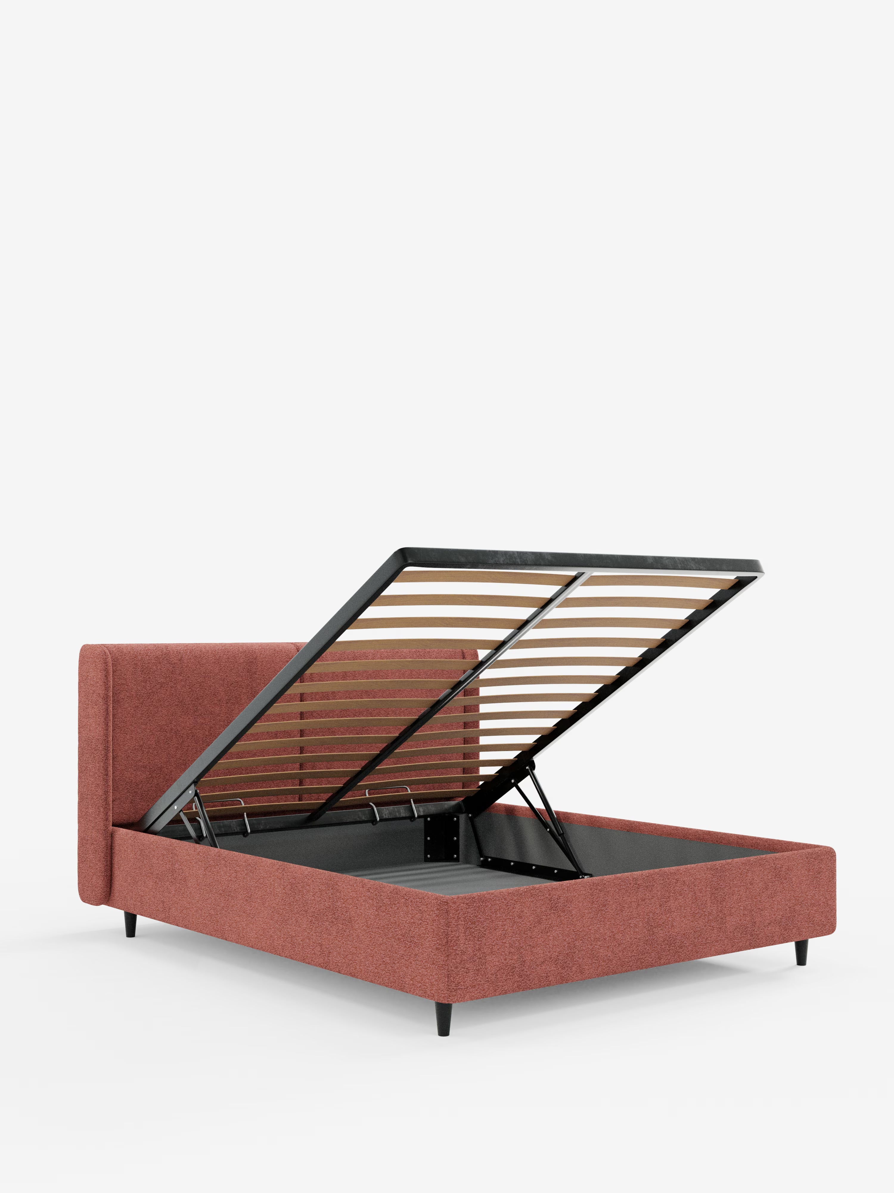 Il letto di design VALKIRIA con vano contenitore e testiera avvolgente di Letti.store è un letto contenitore contemporaneo rivestito in morbido tessuto Oeko-Tex® color ruggine. Caratterizzato da linee pulite e da una testiera rettangolare con due cuscini imbottiti, questo versatile letto contenitore presenta piedini neri e doghe in legno visibili quando si solleva la struttura del materasso per rivelare l’ampio vano contenitore sottostante. Il design moderno risalta sullo sfondo bianco.