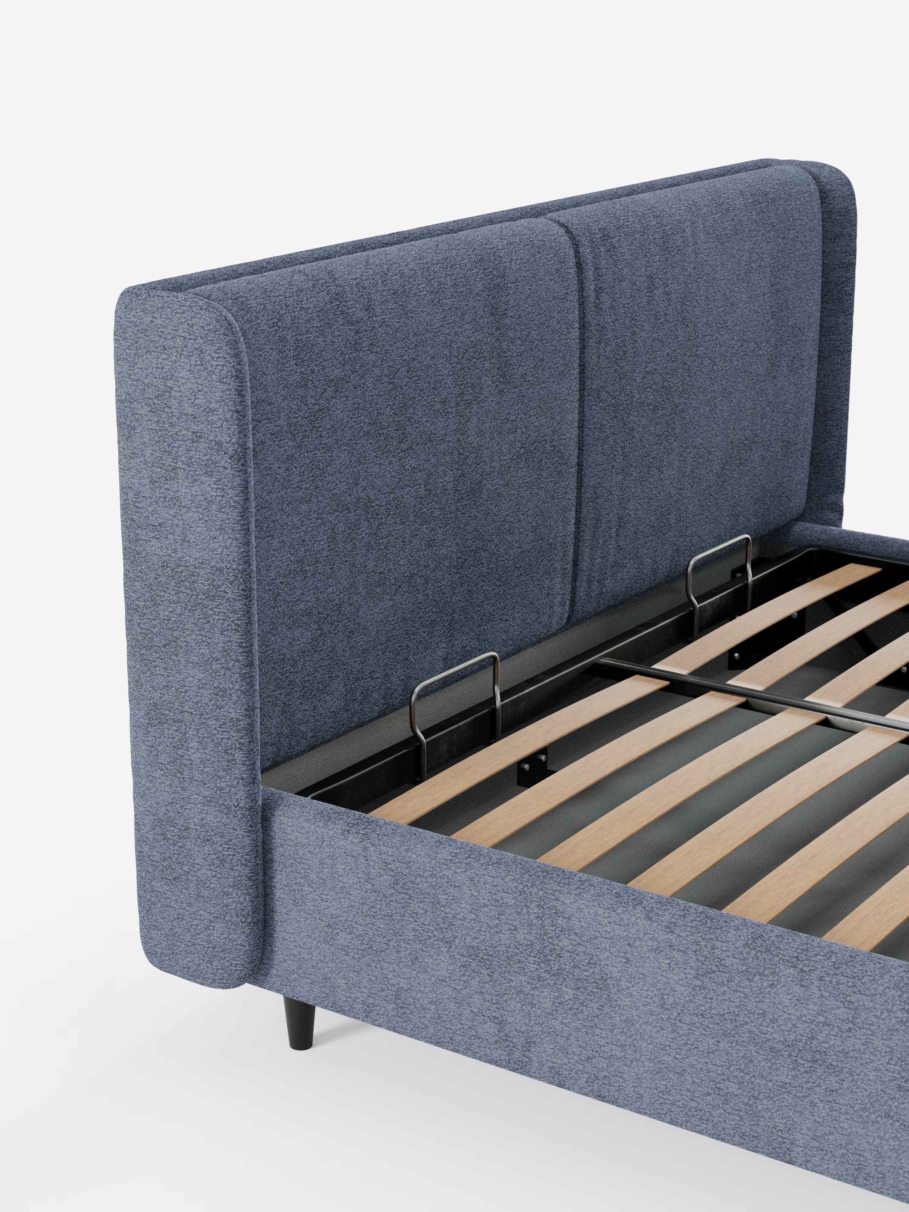 Un primo piano del letto di design VALKIRIA di Letti.Il modello presenta una testiera e una pediera imbottite di colore blu con due cuscini imbottiti in tessuto Oeko-Tex®, un vano contenitore integrato, robuste doghe in legno per il sostegno del materasso, un elegante telaio in metallo nero e gambe corte nere: il tutto messo in risalto su uno sfondo bianco per incarnare alla perfezione il design contemporaneo.