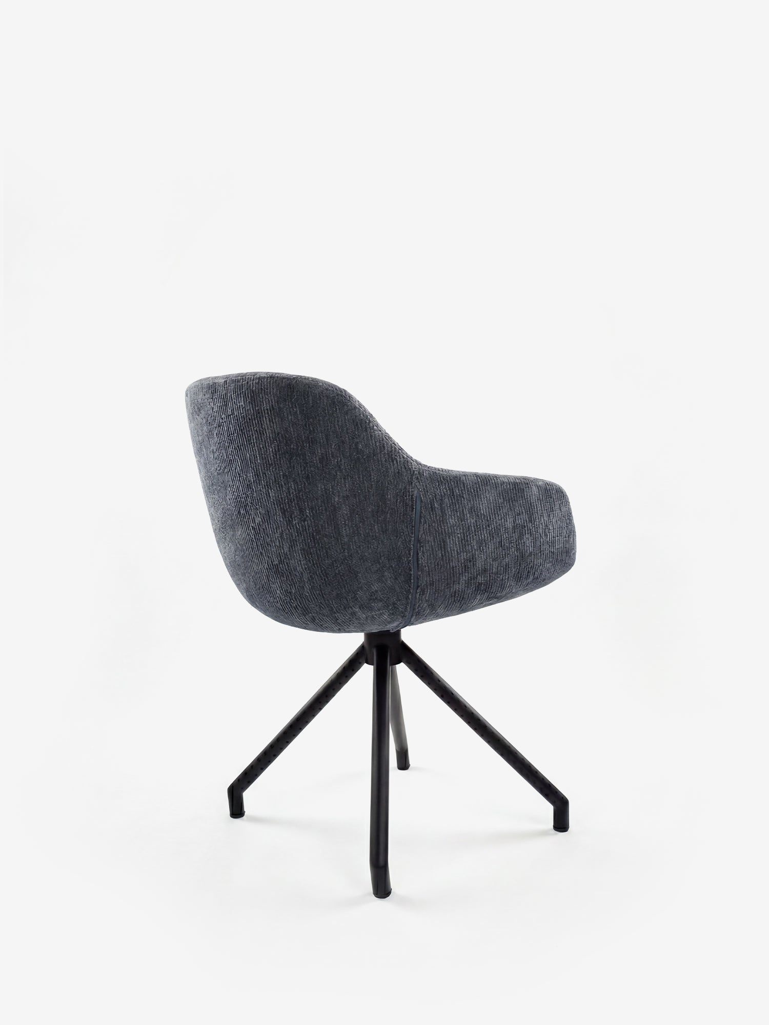 La sedia imbottita Vico di Divani.Store presenta una seduta e uno schienale arrotondati, in tessuto grigio testurizzato morbido al tatto e certificato OEKO-TEX®, oltre a quattro gambe angolate in metallo nero. Ideale come sedia da sala da pranzo, è raffigurata su uno sfondo bianco, leggermente di spalle rispetto all’osservatore.