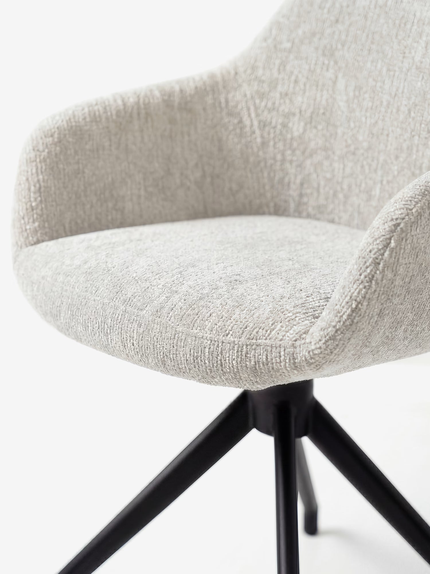 La sedia imbottita Vico di Divani.Store è realizzata in tessuto ciniglia OEKO-TEX® grigio chiaro dal tocco morbido, presenta braccioli ricurvi e una base in metallo nero con quattro gambe angolate; nella foto è raffigurata su uno sfondo bianco a tinta unita, con visibili solo la parte inferiore della seduta e le gambe.