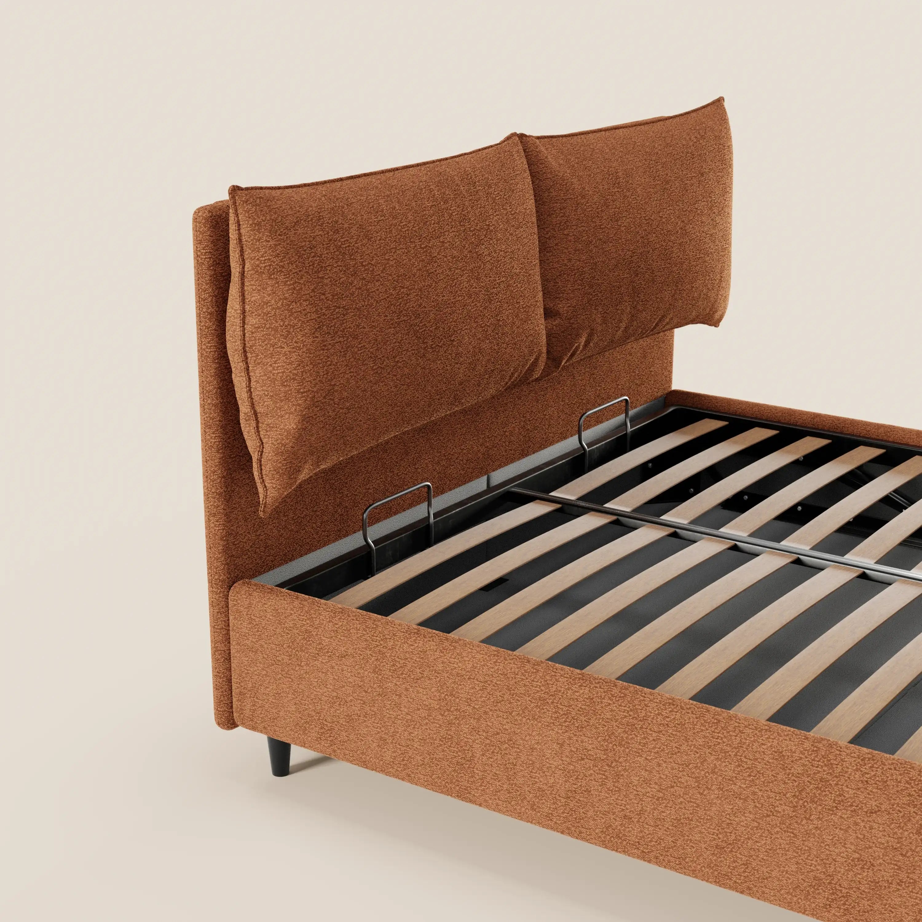 Il letto imbottito ZAYRON di Letti.store è un letto moderno con contenitore, morbidi cuscini regolabili color ruggine e testiera in tessuto Oeko-Tex®, struttura con doghe in legno e barre nere, senza materasso. Sfondo beige chiaro.