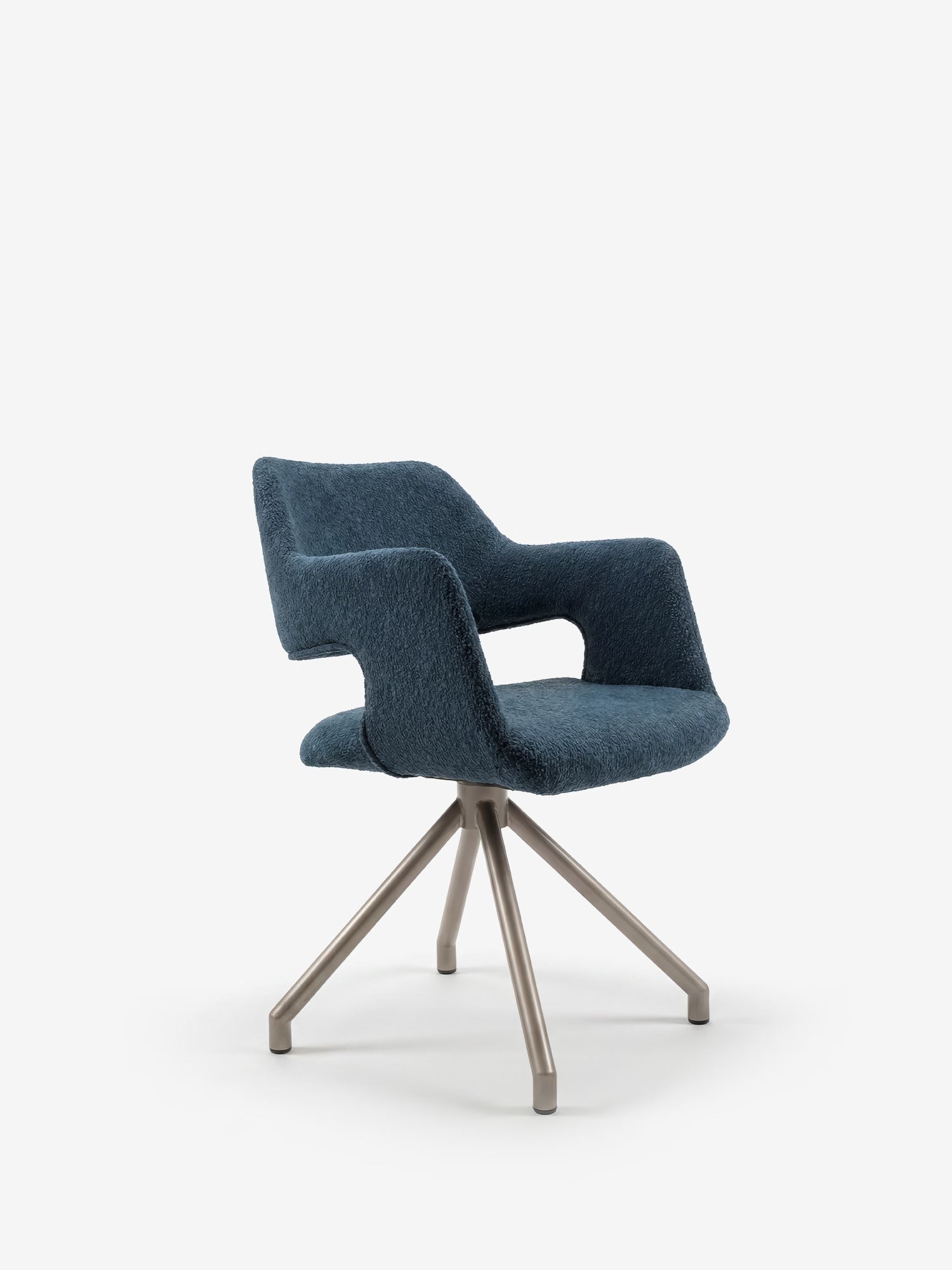 La poltrona imbottita Zefira di Divani.Store presenta braccioli, tessuto blu effetto cotone, uno schienale curvo e una base in metallo con finitura spazzolata color champagne e gambe divaricate. Design moderno; raffigurata su sfondo bianco a tinta unita.