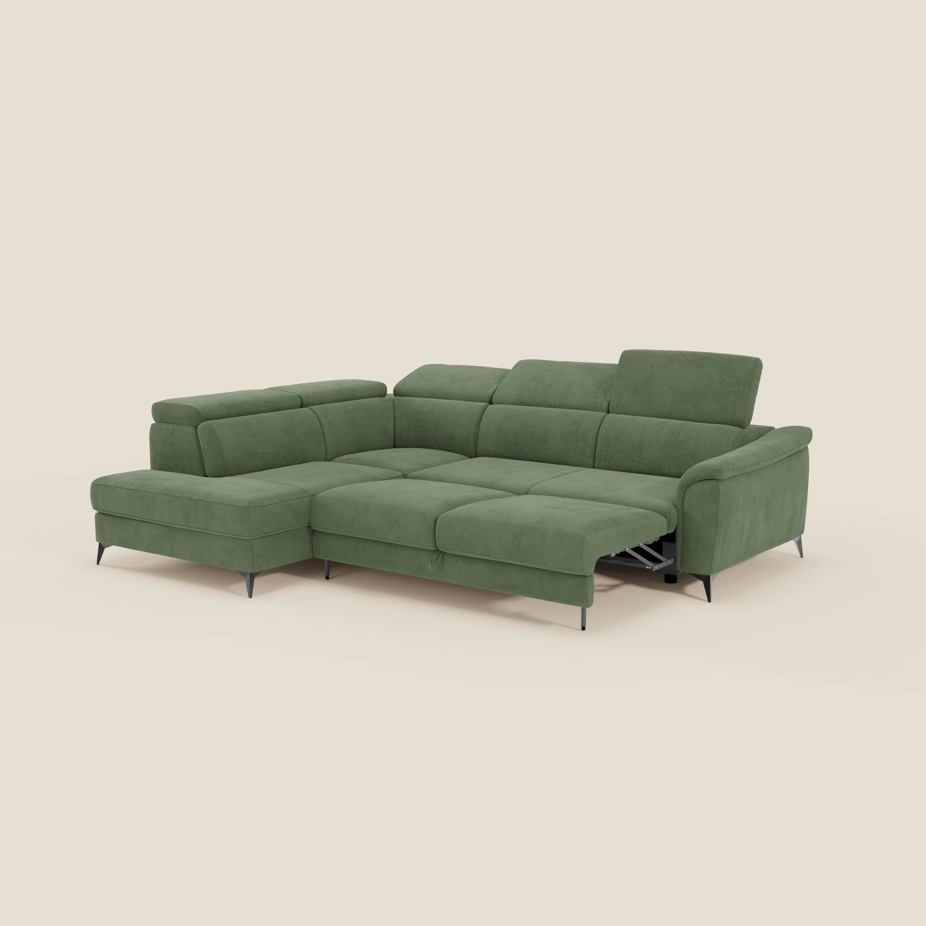 Il divano angolare Arcos di Divani.Store in microfibra impermeabile T11 verde è dotato di poggiatesta reclinabili, chaise longue estraibile a sinistra, poggiapiedi relax elettrico a destra e sottili gambe alte nere. Lo sfondo è beige chiaro.