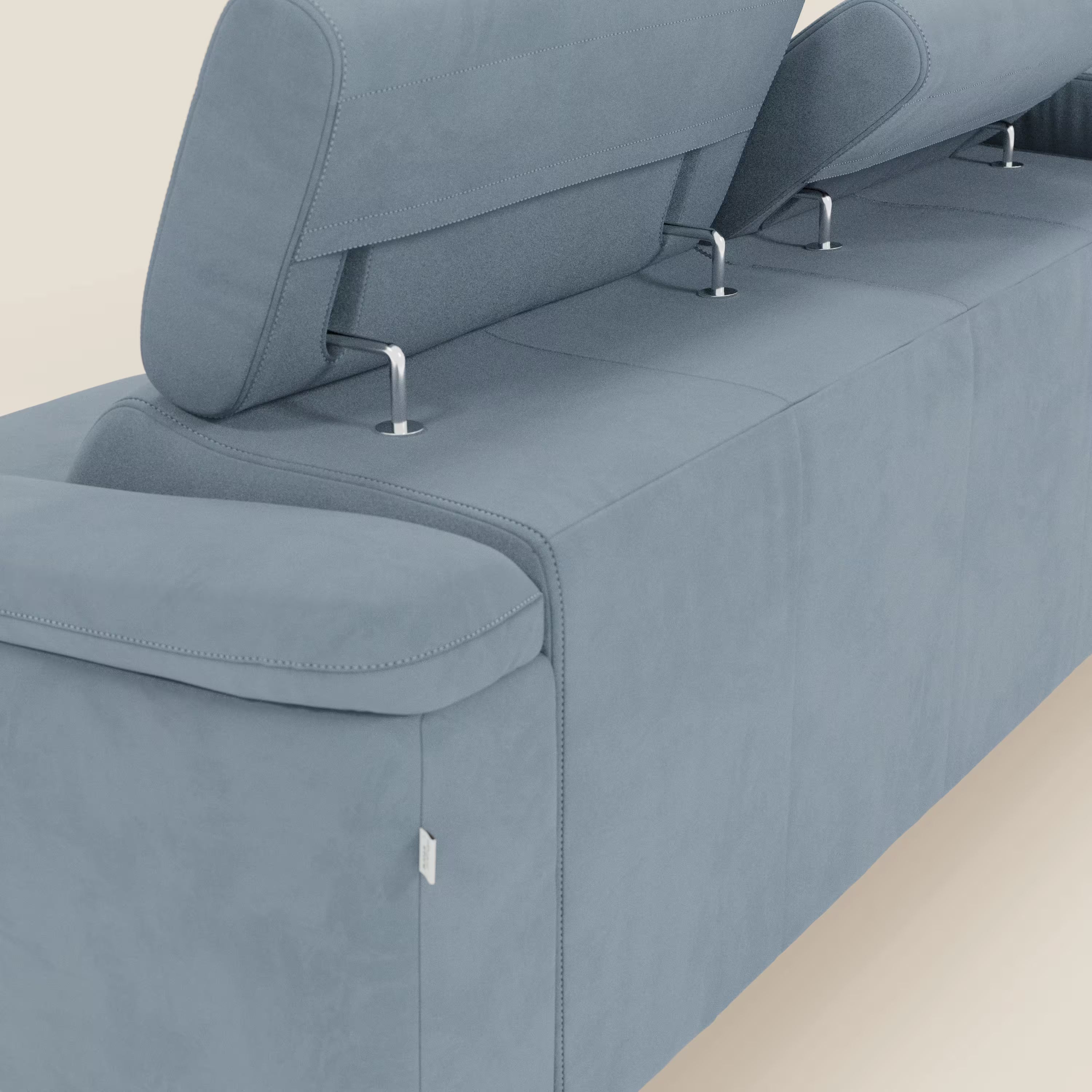 Primo piano dell'Arcos Divano con penisola di Divani.Store, caratterizzato da gambe alte, poggiatesta regolabili e microfibra impermeabile T11 carta da zucchero. Le cuciture a vista e le linee eleganti sottolineano il suo design contemporaneo e minimalista su uno sfondo a tinta unita.