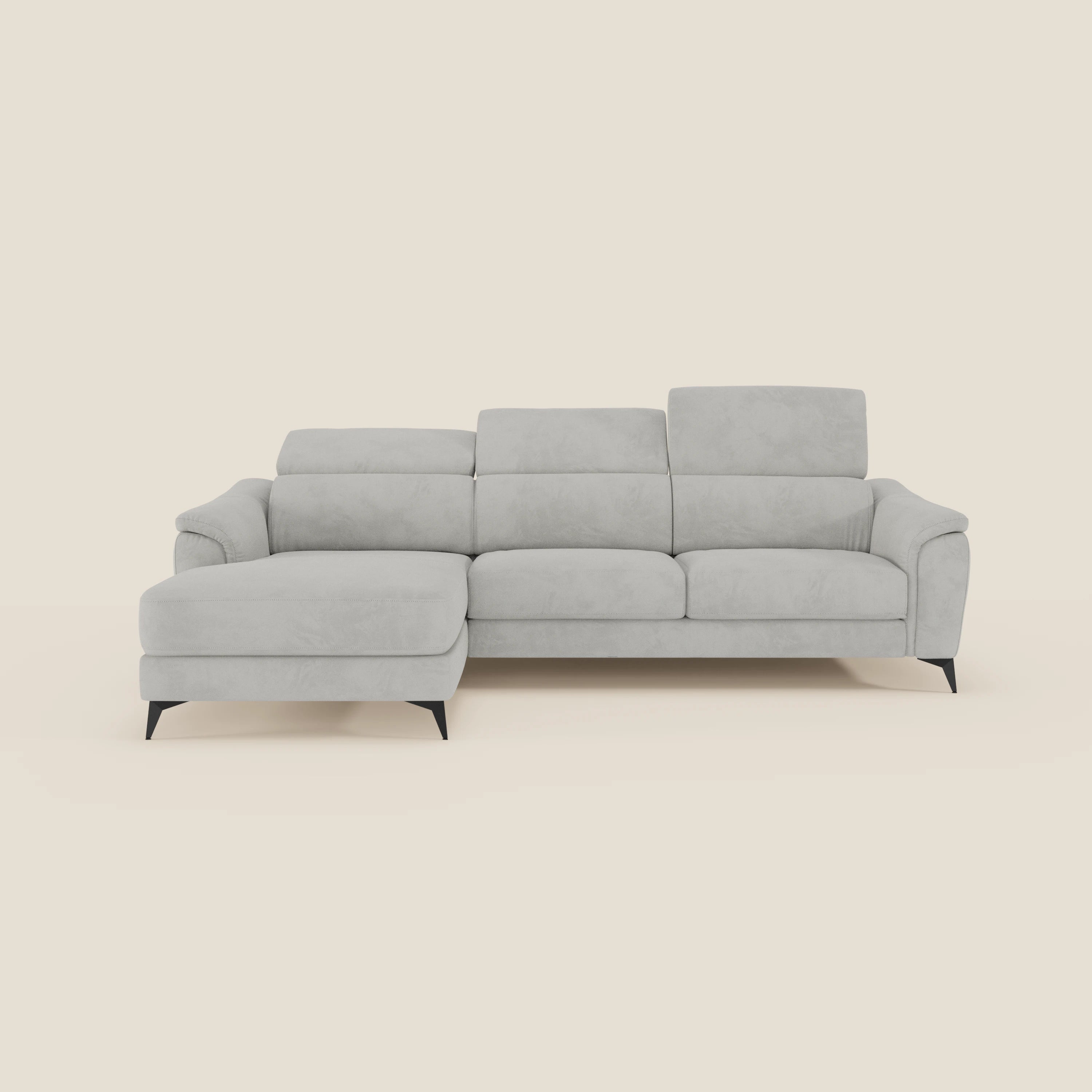 Arcos Divano con penisola di Divani.Store, in microfibra impermeabile T11 grigio chiaro, vanta piedini alti neri e poggiatesta reclinabili. Questo elegante divano di manifattura italiana è inserito in un semplice sfondo bianco sporco.