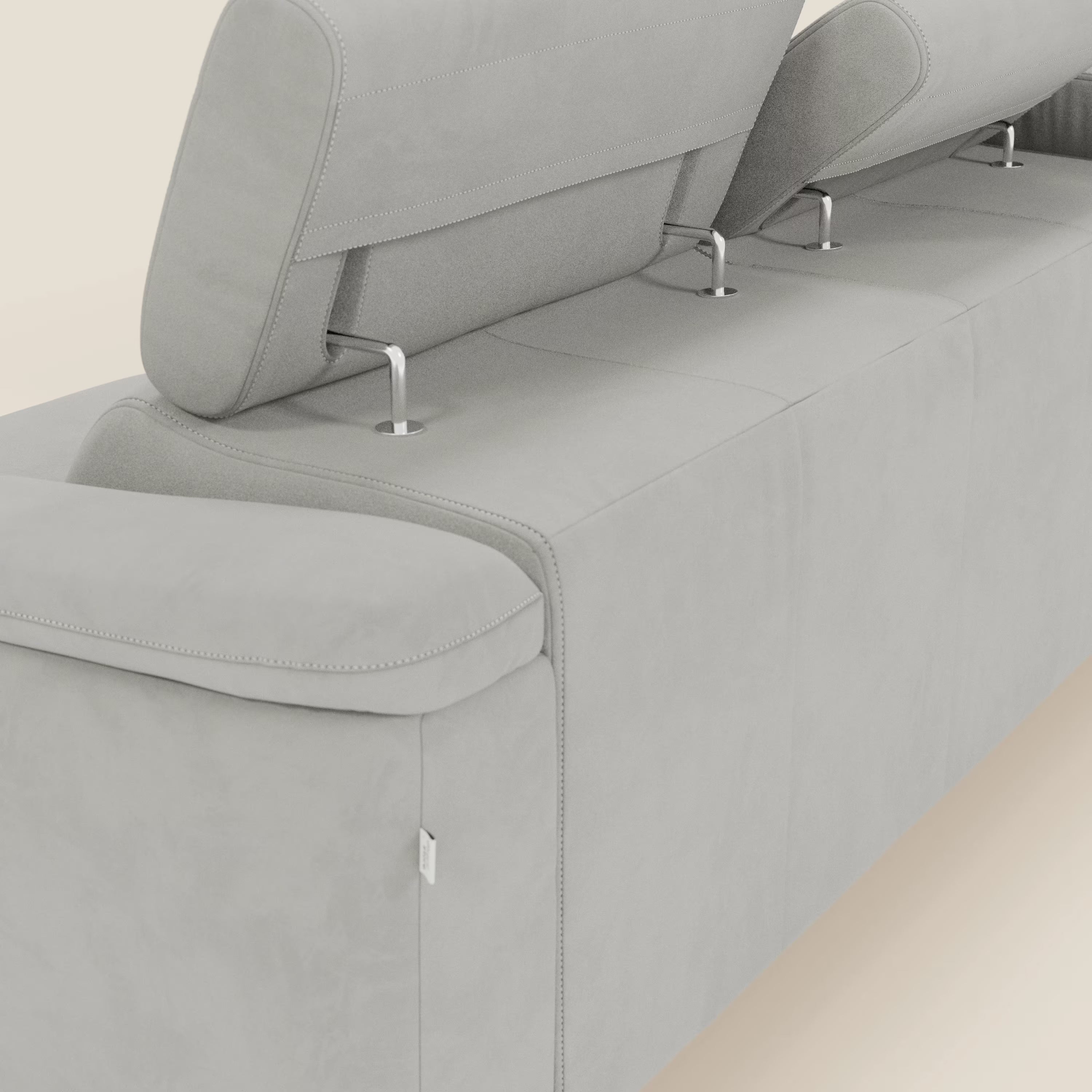 Primo piano dell'Arcos Divano con penisola di Divani.Store in microfibra impermeabile grigio chiaro T11, con due poggiatesta regolabili, gambe alte in metallo e cuciture doppie, visto da dietro su un semplice sfondo bianco sporco.