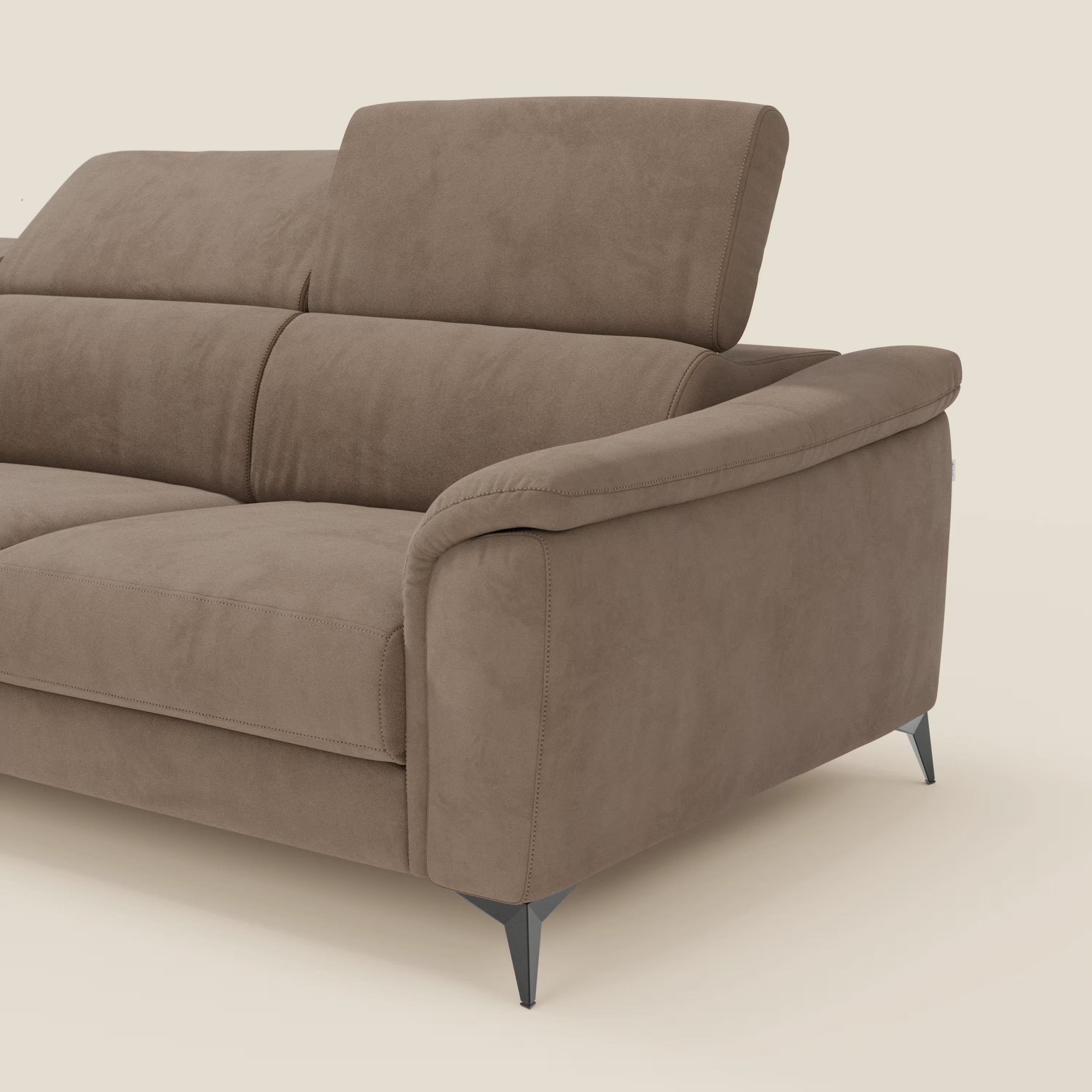 L'Arcos Divano con penisola di Divani.Store in microfibra impermeabile marrone T11 è caratterizzato da alte gambe in metallo e poggiatesta reclinabili. Solo il lato destro è mostrato su uno sfondo bianco sporco, che mette in evidenza il suo design moderno e i braccioli morbidi.