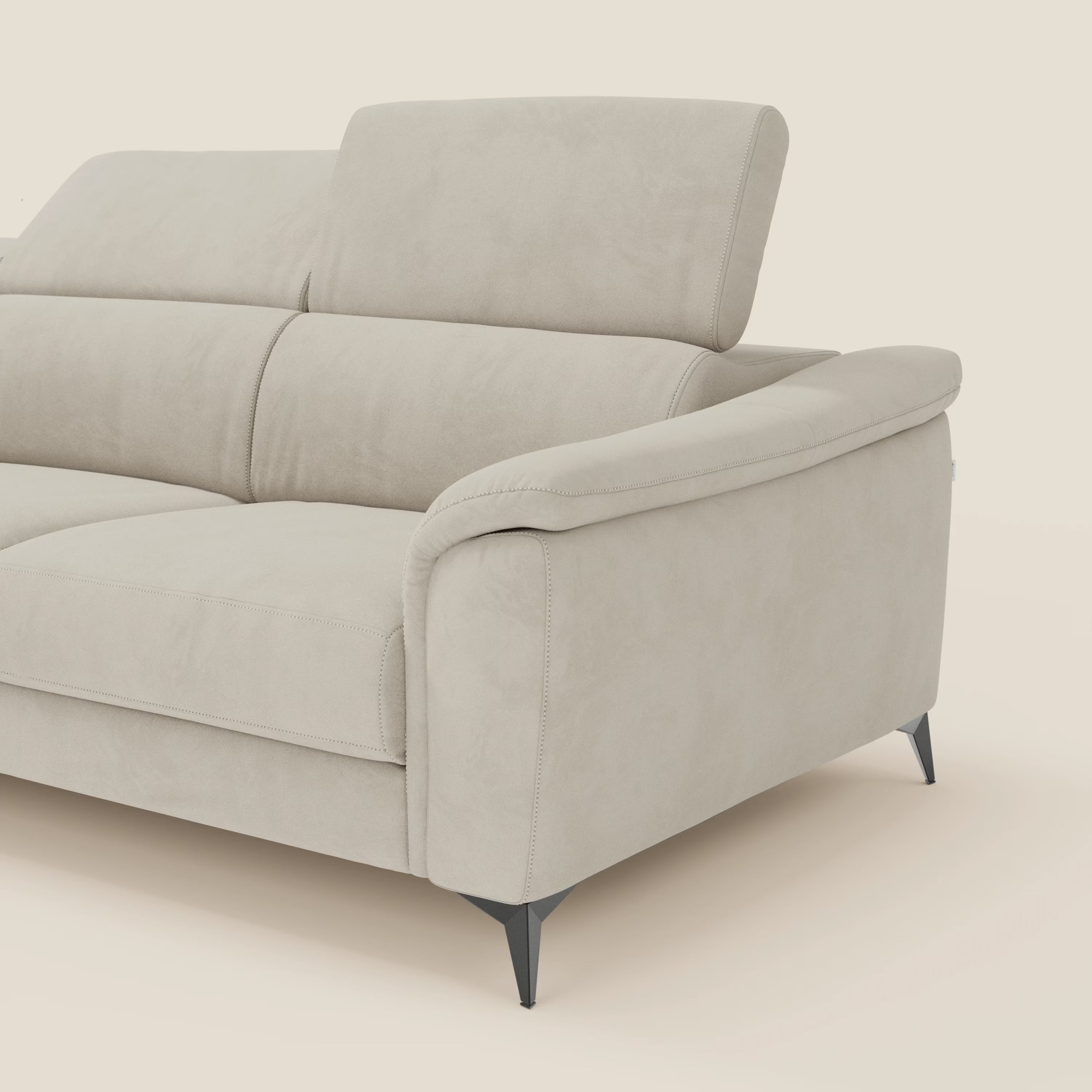 L'Arcos Divano con penisola di Divani.Store, presentato in microfibra impermeabile panna T11, è caratterizzato da gambe alte, un ampio bracciolo, cuscini morbidi e un poggiatesta reclinabile: un esempio di alta manifattura italiana.