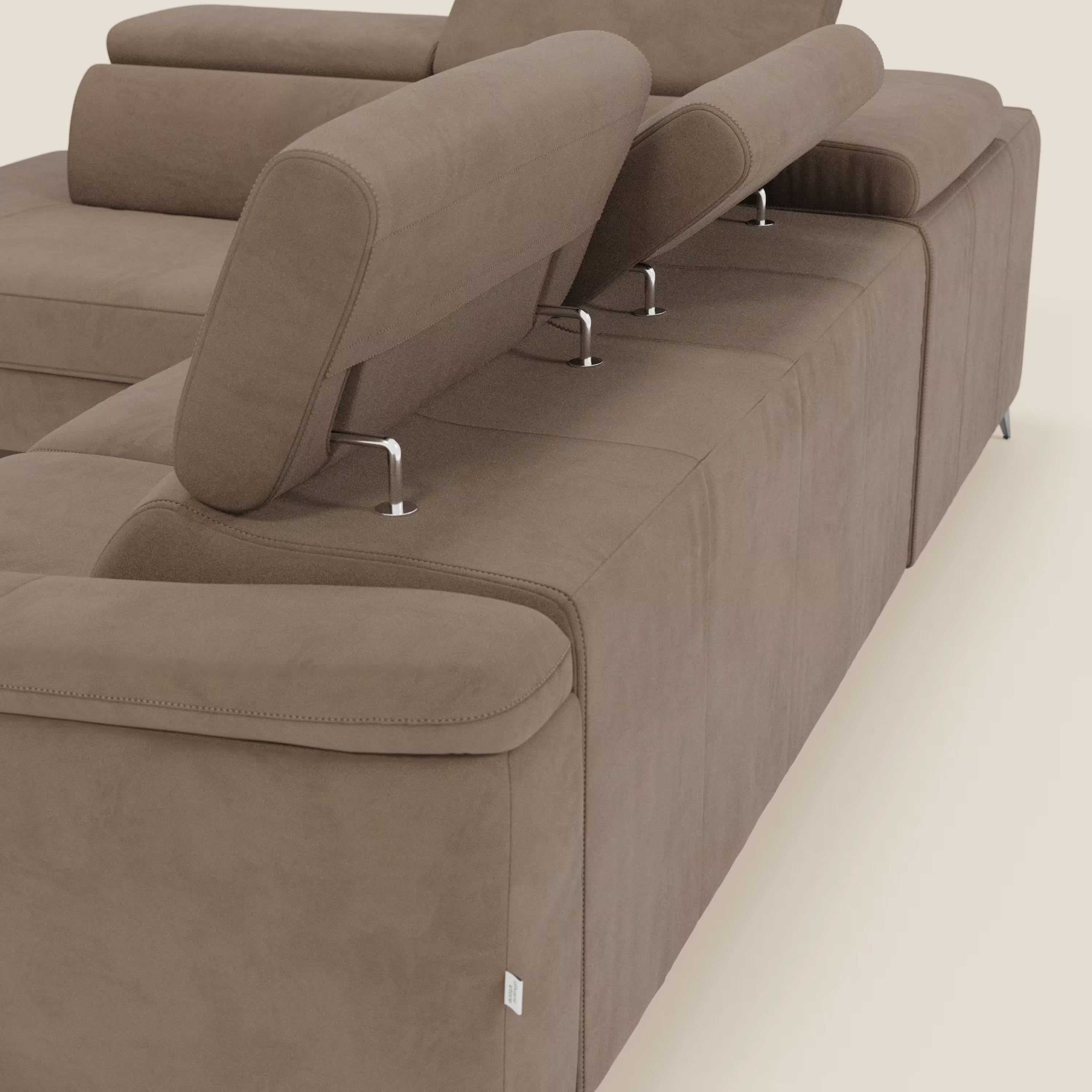 Il divano angolare Arcos di Divani.Store, visto di schiena e di lato, è caratterizzato da alti piedi cromati, poggiatesta regolabili, cuciture a vista e rivestimento in microfibra impermeabile marrone T11.