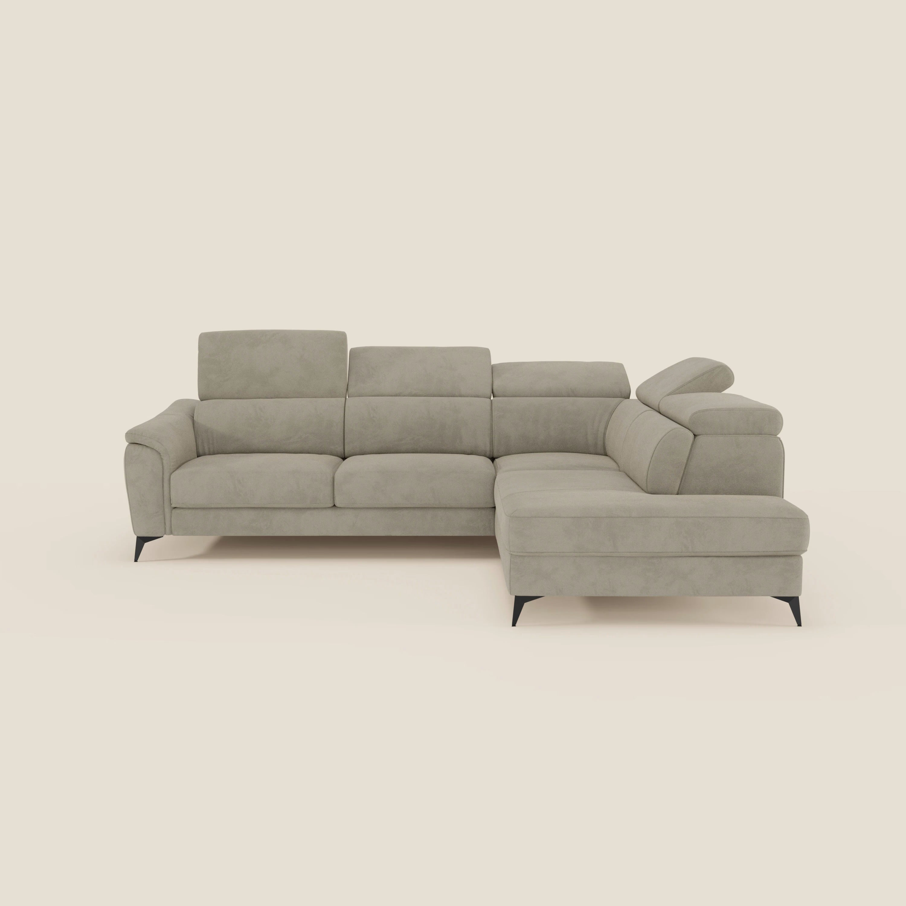 Il divano angolare Arcos di Divani.Store è caratterizzato da alte gambe in metallo nero, poggiatesta reclinabili e microfibra impermeabile color taupe T11. Una chaise longue estraibile sulla destra invita a rilassarsi, in questo caso su uno sfondo bianco sporco.