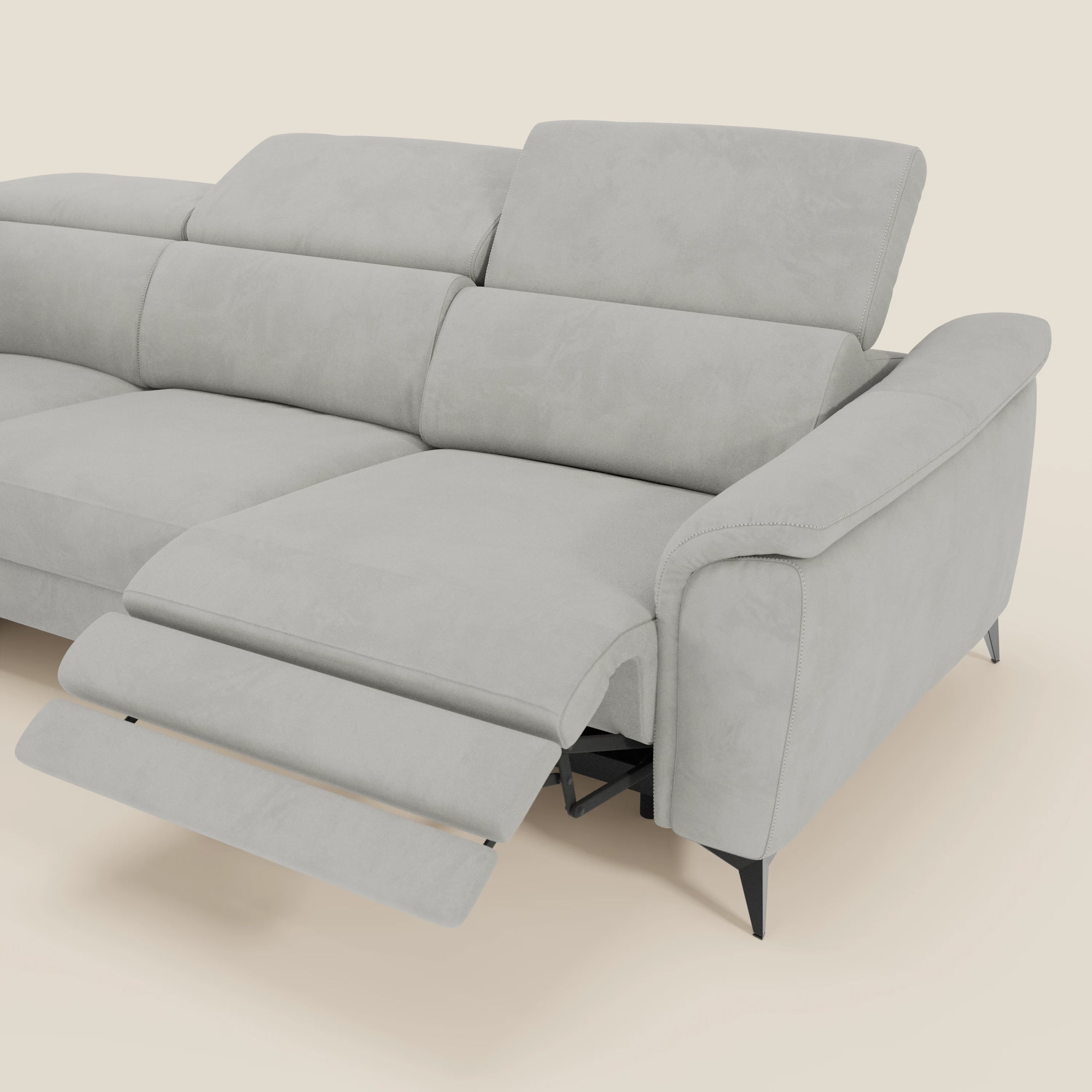 Arcos Divano angolare di Divani.Store è caratterizzato da alte gambe in metallo nero, poggiatesta reclinabili e rivestimento in microfibra impermeabile T11 grigio chiaro, con chaise longue sul lato destro, il tutto su uno sfondo beige semplice.