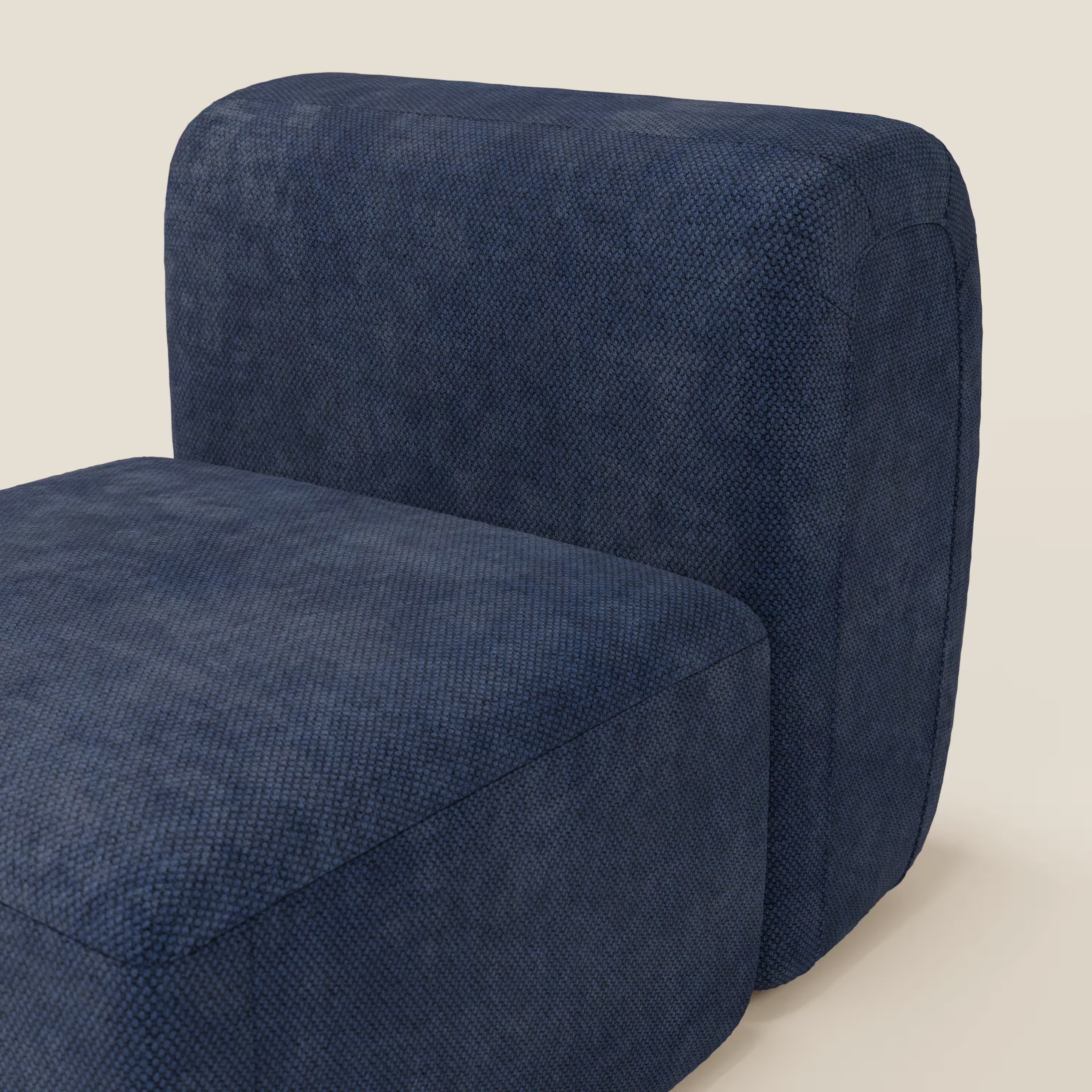 Un primo piano del BonBon modulo centrale 70 cm - Grande Fratello edition blu navy di Divani.Store mostra il tessuto testurizzato blu scuro, gli spessi cuscini arrotondati e le linee pulite su uno sfondo beige chiaro. Sono visibili solo parte della seduta e dello schienale.