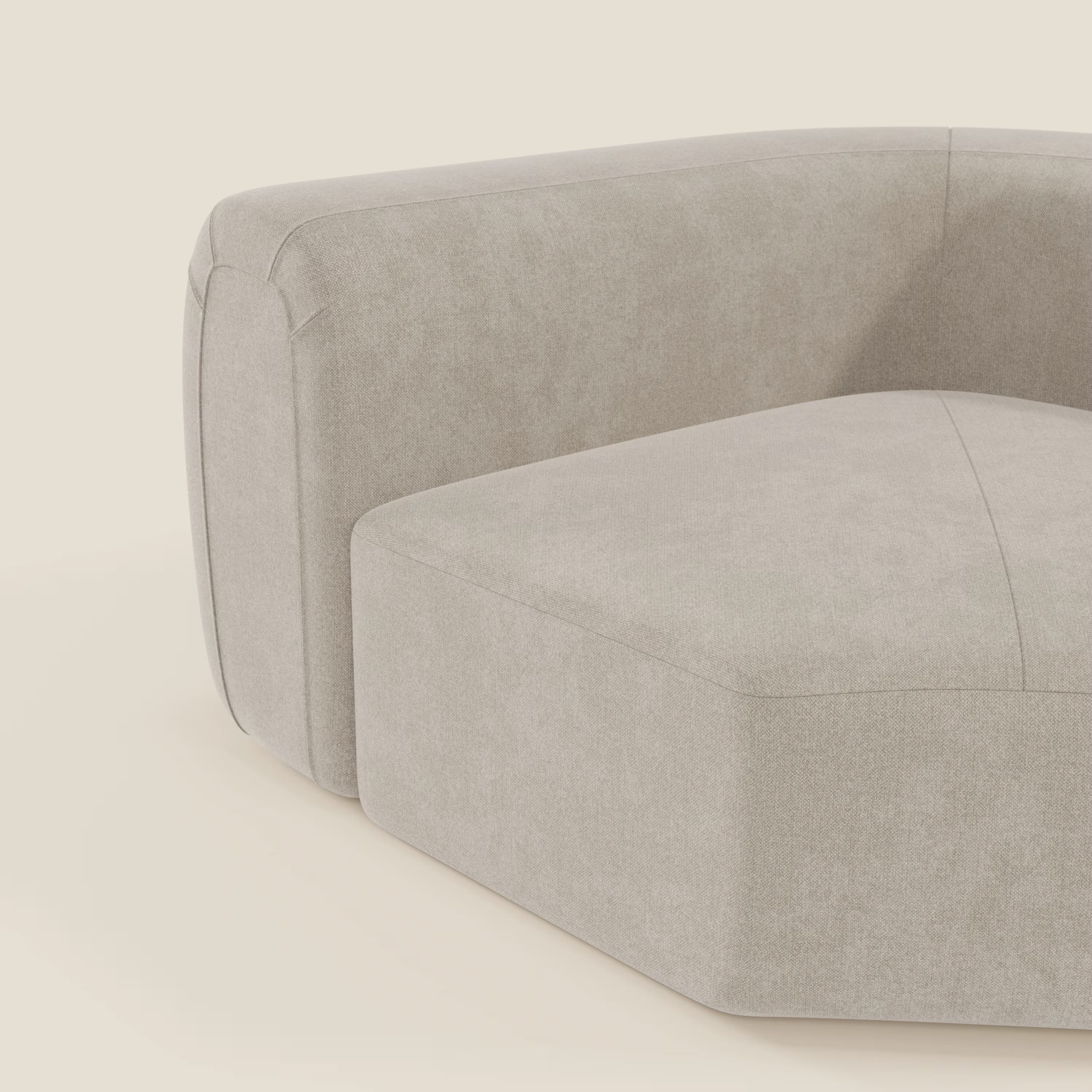 Un primo piano di Bonbon Modulo angolare di Divani.Store, un moderno divano modulare in tessuto panna T23, facile da pulire, con una texture liscia, cuciture evidenti e linee geometriche eleganti: la sua tonalità neutra spicca su un semplice sfondo bianco sporco.