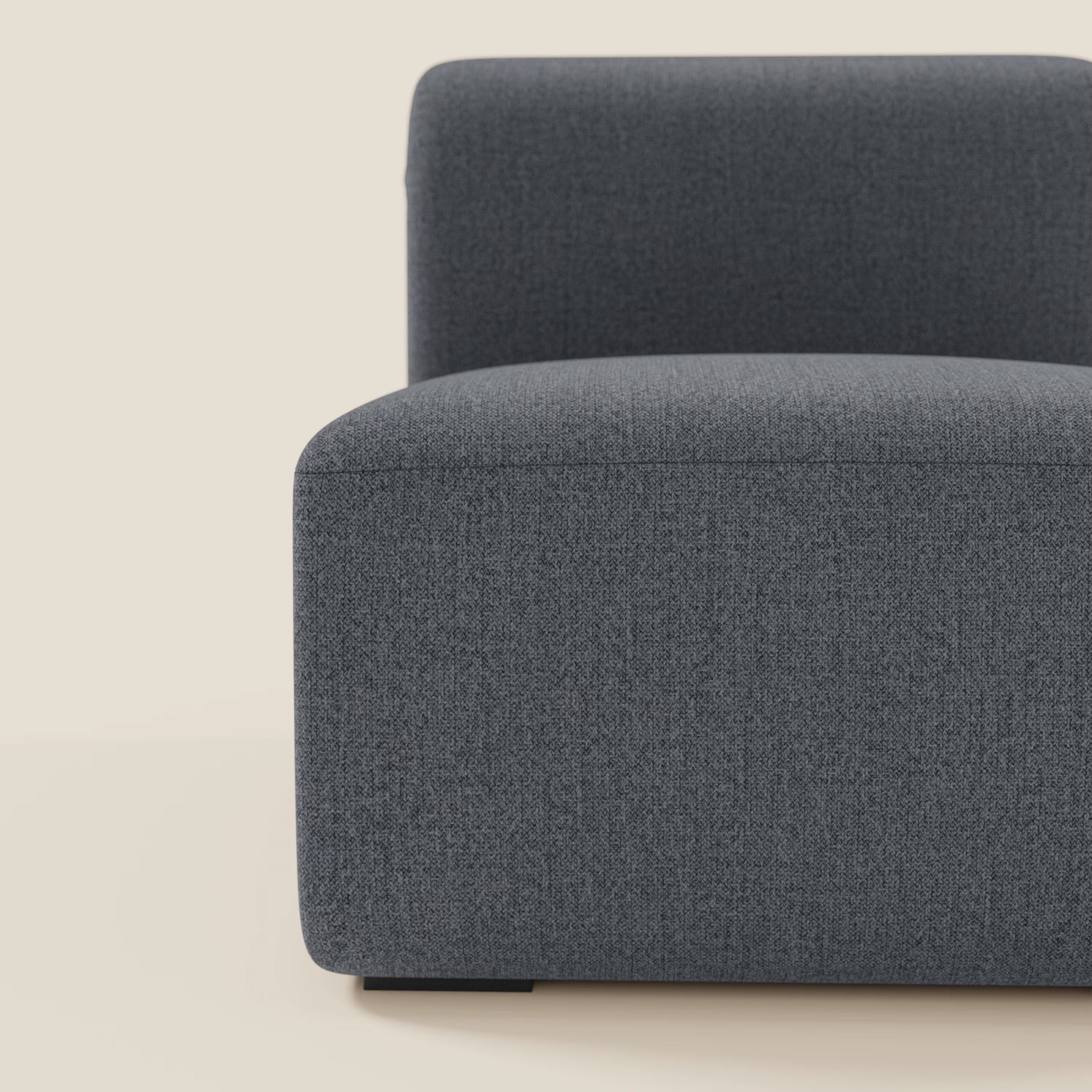 Primo piano di BonBon modulo centrale 70 cm di Divani.Store, una seduta o un elemento componibile moderno e minimalista in tessuto grafite antimacchia T23 blu dalle linee squadrate, presentato su uno sfondo beige chiaro.