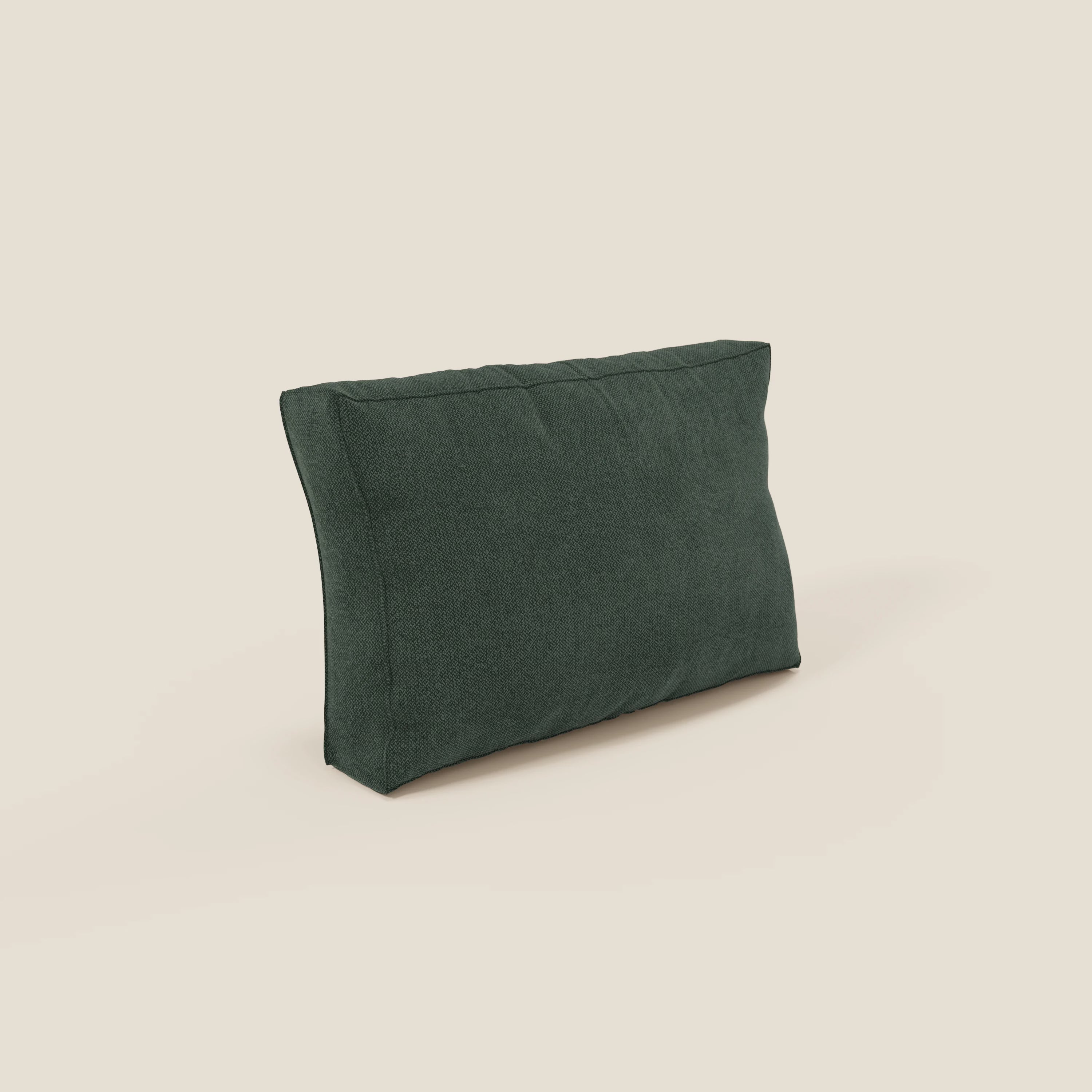 Un cuscino schienale rettangolare BonBon verde scuro di Divani.Store si erge su uno sfondo beige chiaro. Morbido e vellutato in tessuto smacchiabile T23 verde, presenta semplici cuciture sui bordi ed è disponibile in 2 misure.