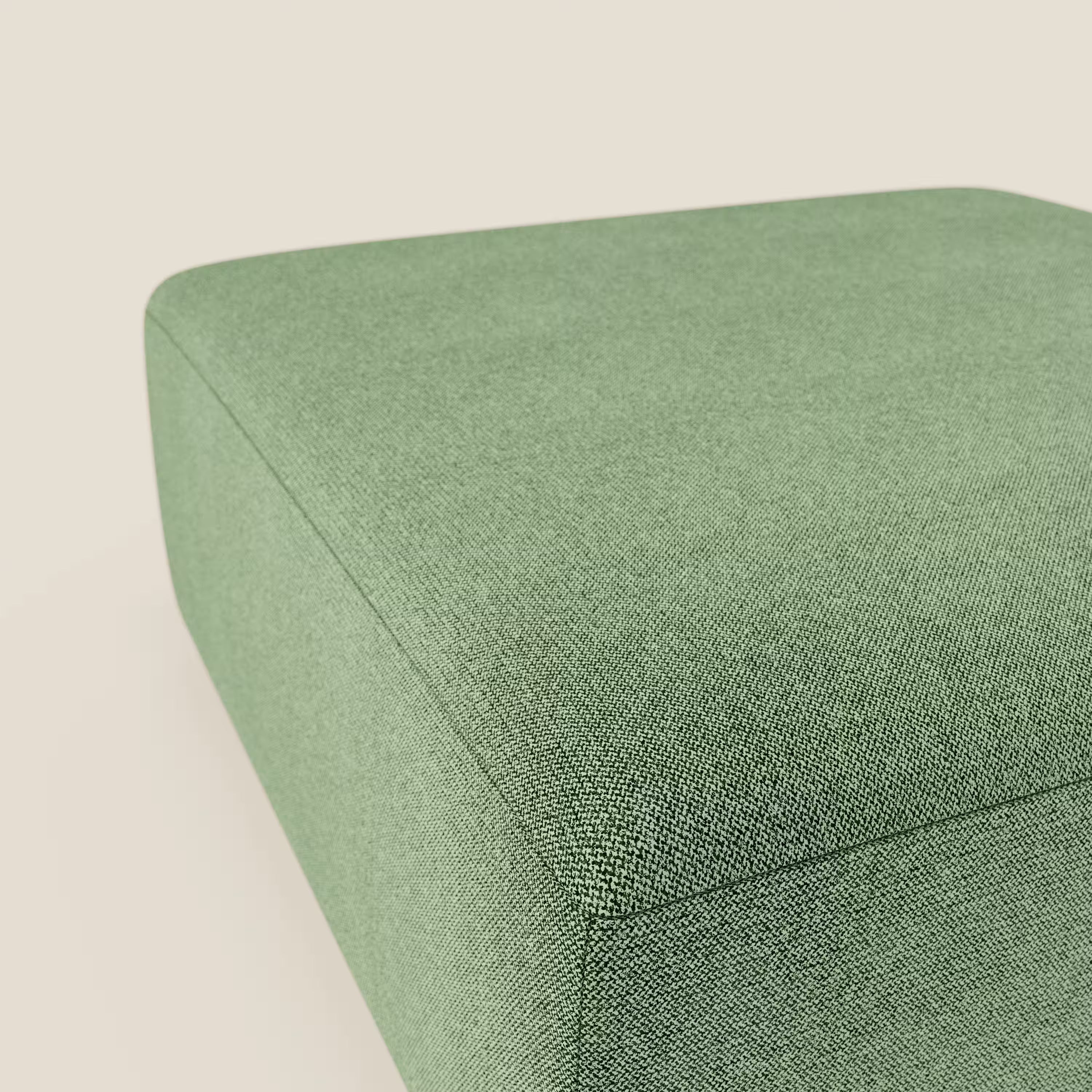 Primo piano del pouf divano modulare BonBon di Divani.Store in tessuto T23 menta smacchiabile, caratterizzato da una texture morbida, bordi puliti e design moderno su uno sfondo beige chiaro. Disponibile in 2 misure.