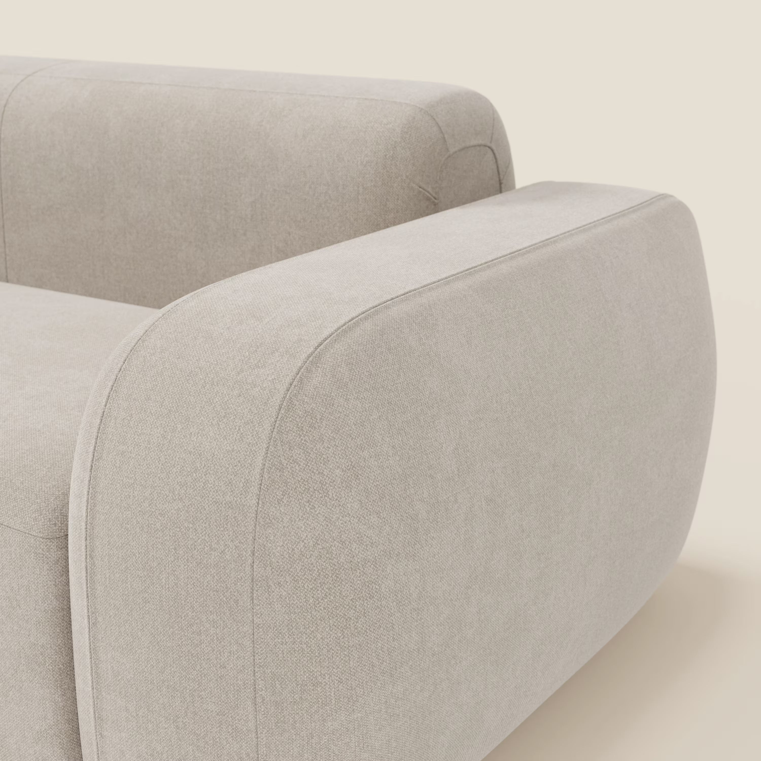 Primo piano del BonBon Divano modulare Lineare 220 di Divani.Store: un divano moderno in tessuto panna smacchiabile chiaro con braccioli spessi e arrotondati e seduta unica per un look elegante e senza soluzione di continuità su uno sfondo semplice.