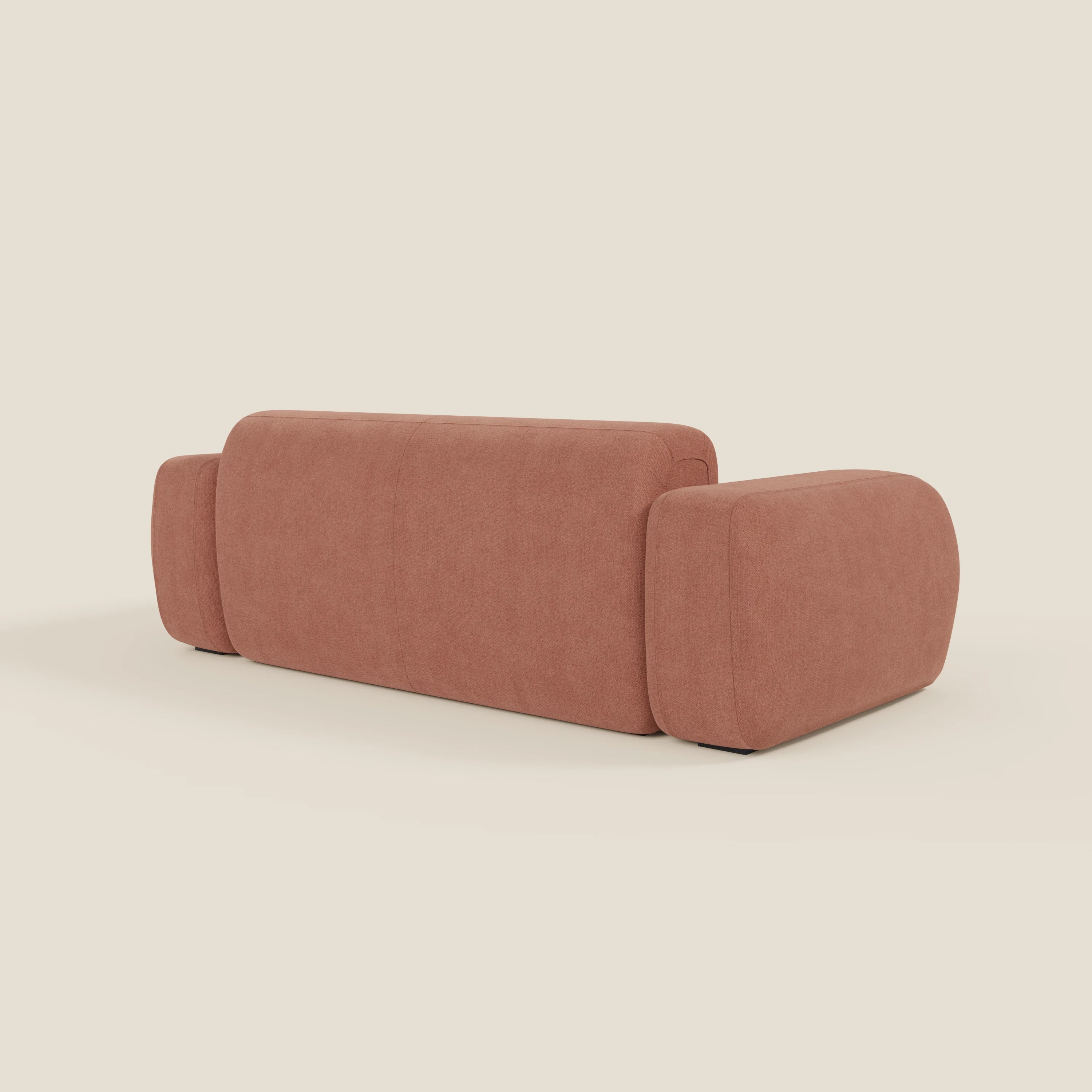 Il BonBon Divano modulare Lineare 220 di Divani.Store, presentato dal retro in tessuto smacchiabile T23 pesca, presenta un design minimalista con bordi arrotondati, ampi braccioli e un profilo basso su uno sfondo beige semplice.