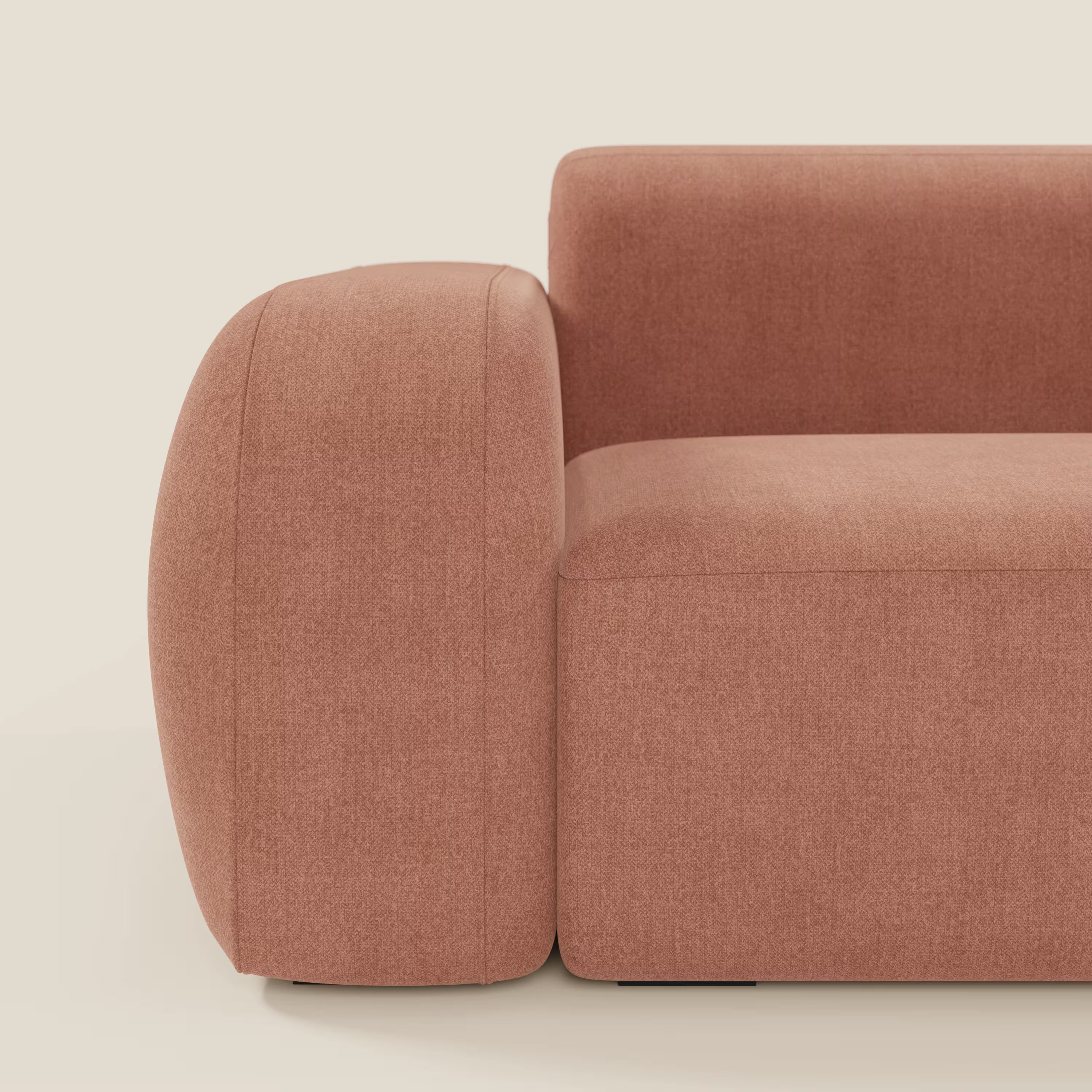 Una vista laterale ravvicinata del BonBon Divano modulare Lineare 220 di Divani.Store, caratterizzato da bordi arrotondati e braccioli in tessuto smacchiabile T23 pesca, mostra il suo design minimalista e contemporaneo su uno sfondo chiaro.