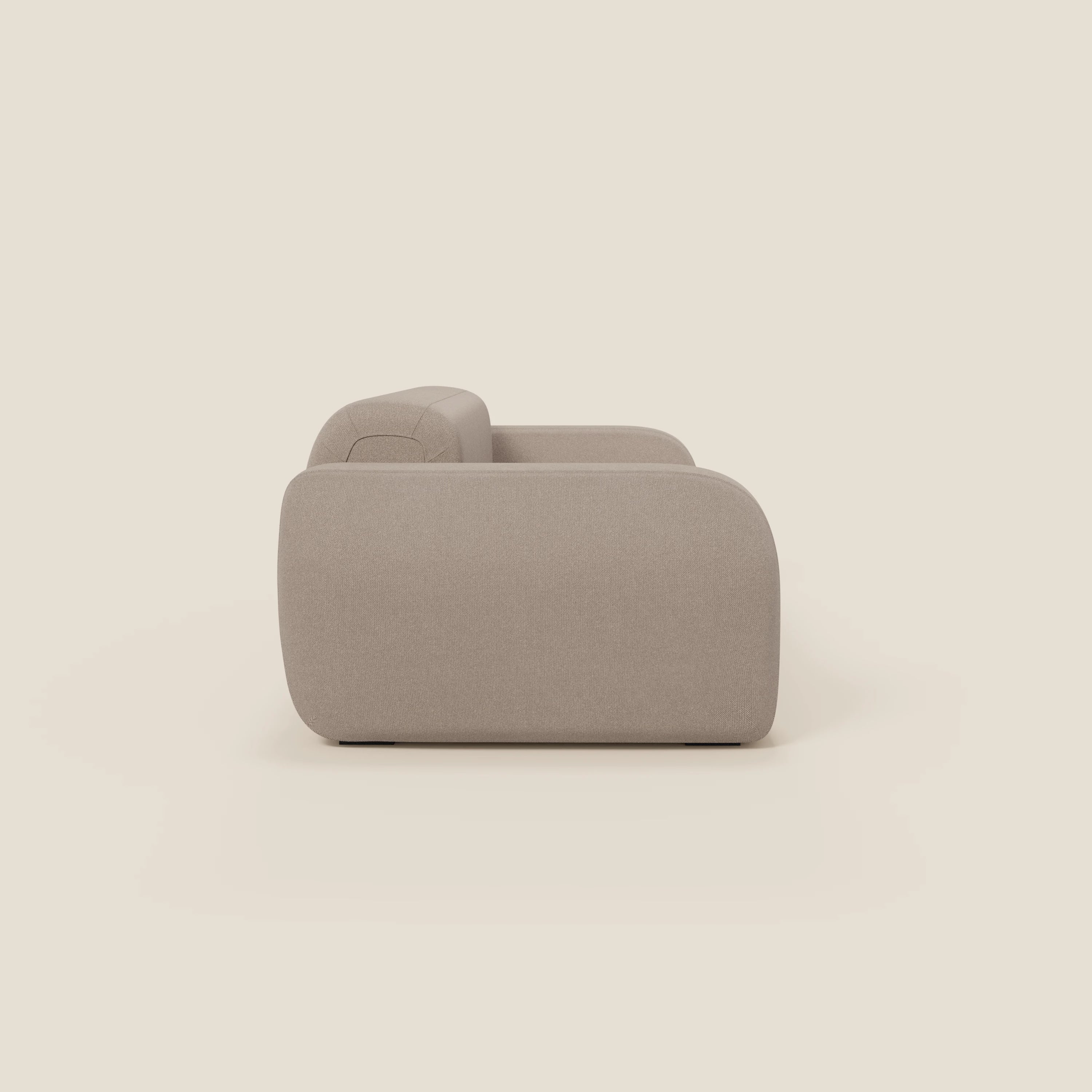 Il BonBon Divano modulare Lineare 220 di Divani.Store, in tessuto smacchiabile T23 tortora, è presentato lateralmente. Il bracciolo e lo schienale, lisci e arrotondati, si stagliano su uno sfondo chiaro, sottolineando il suo design minimalista e contemporaneo. Non compaiono altri oggetti.