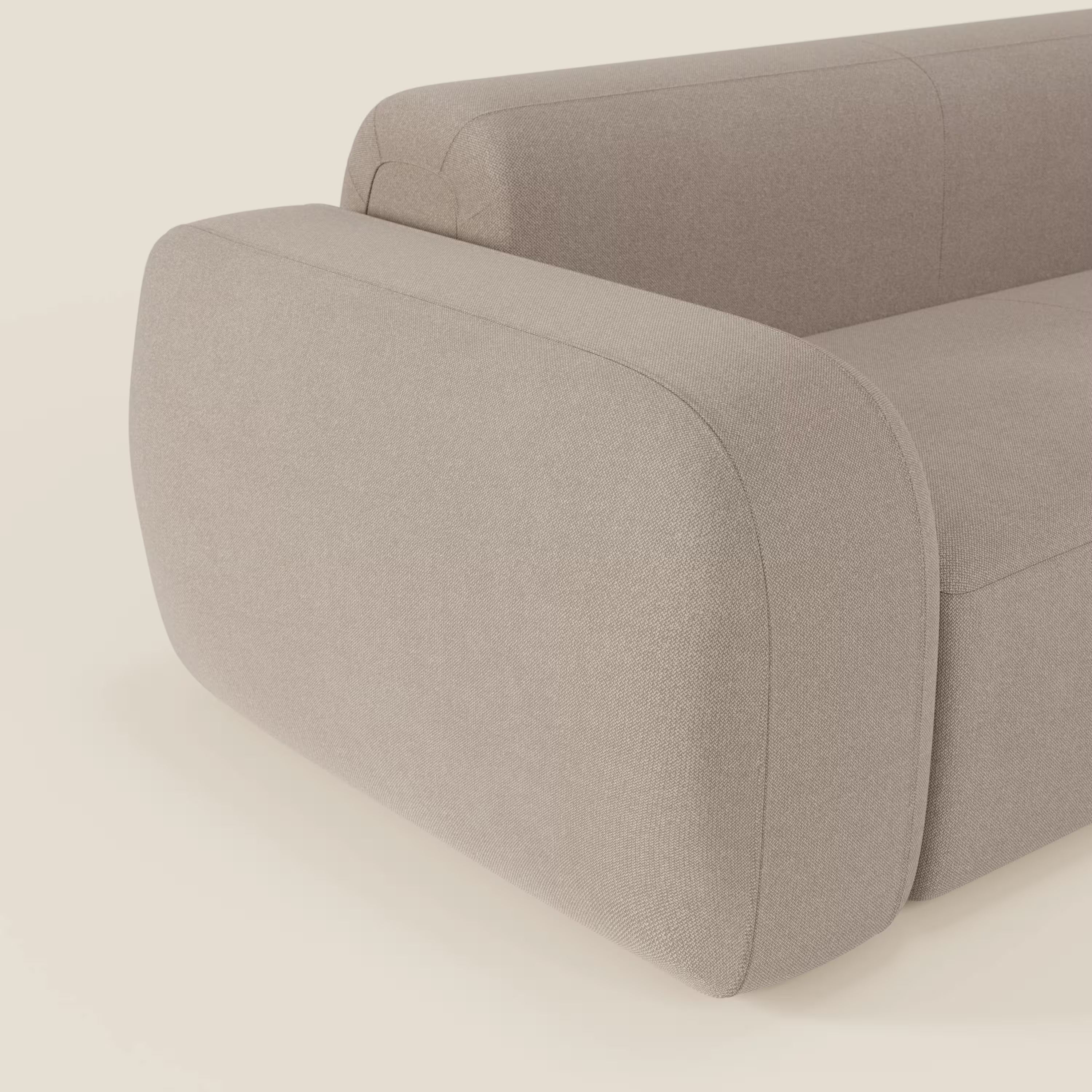 Primo piano del BonBon Divano modulare Lineare 220 di Divani.Store in tessuto smacchiabile T23 tortora, caratterizzato da bordi lisci e arrotondati e braccioli imbottiti per un look moderno e minimalista su uno sfondo semplice.