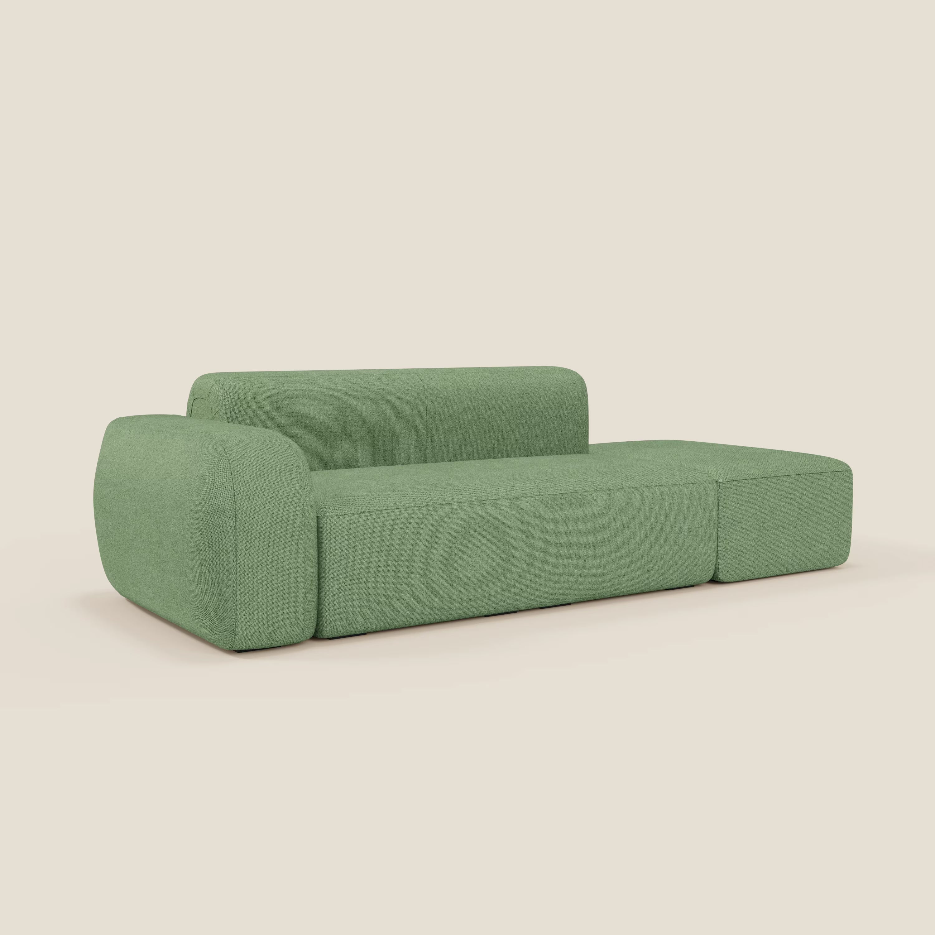 Il divano modulare componibile BonBon di Divani.Store è caratterizzato da un design minimalista in tessuto smacchiabile T23 menta, con bordi arrotondati, schienale basso e pouf allungabile a destra, su uno sfondo beige tinta unita.