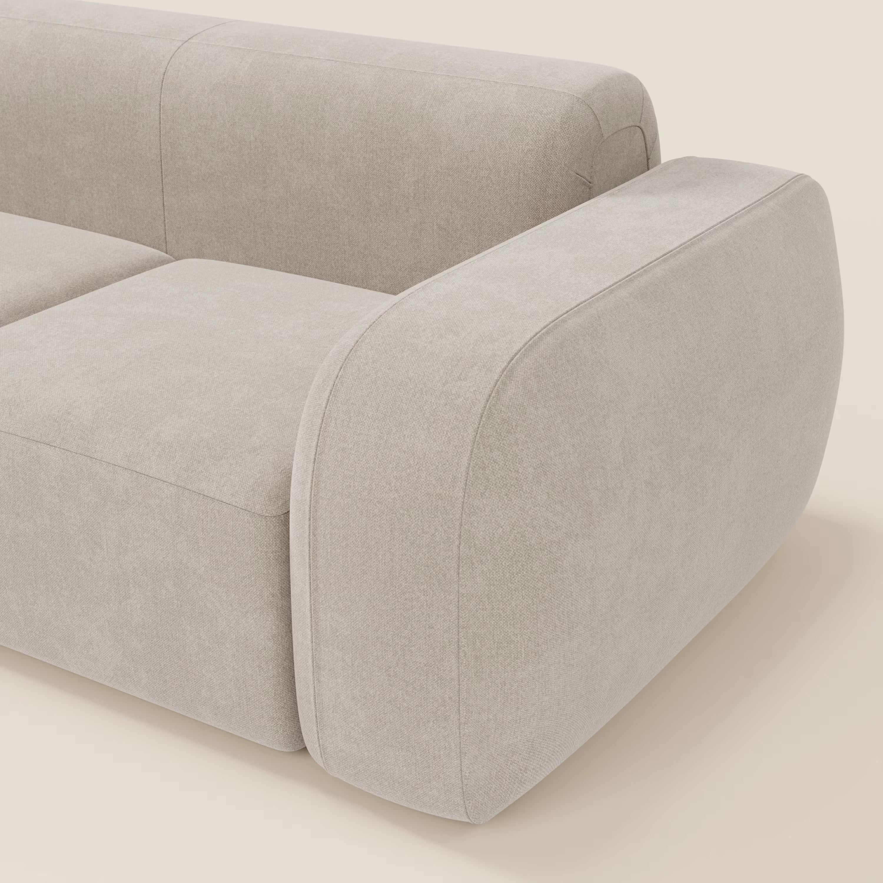 Primo piano del BonBon Divano componibile - Composizione Spaccamattone in tessuto smacchiabile T23 panna di Divani.Store, caratterizzato da cuscini morbidi, ampi braccioli curvi e un design pulito e minimalista color crema.