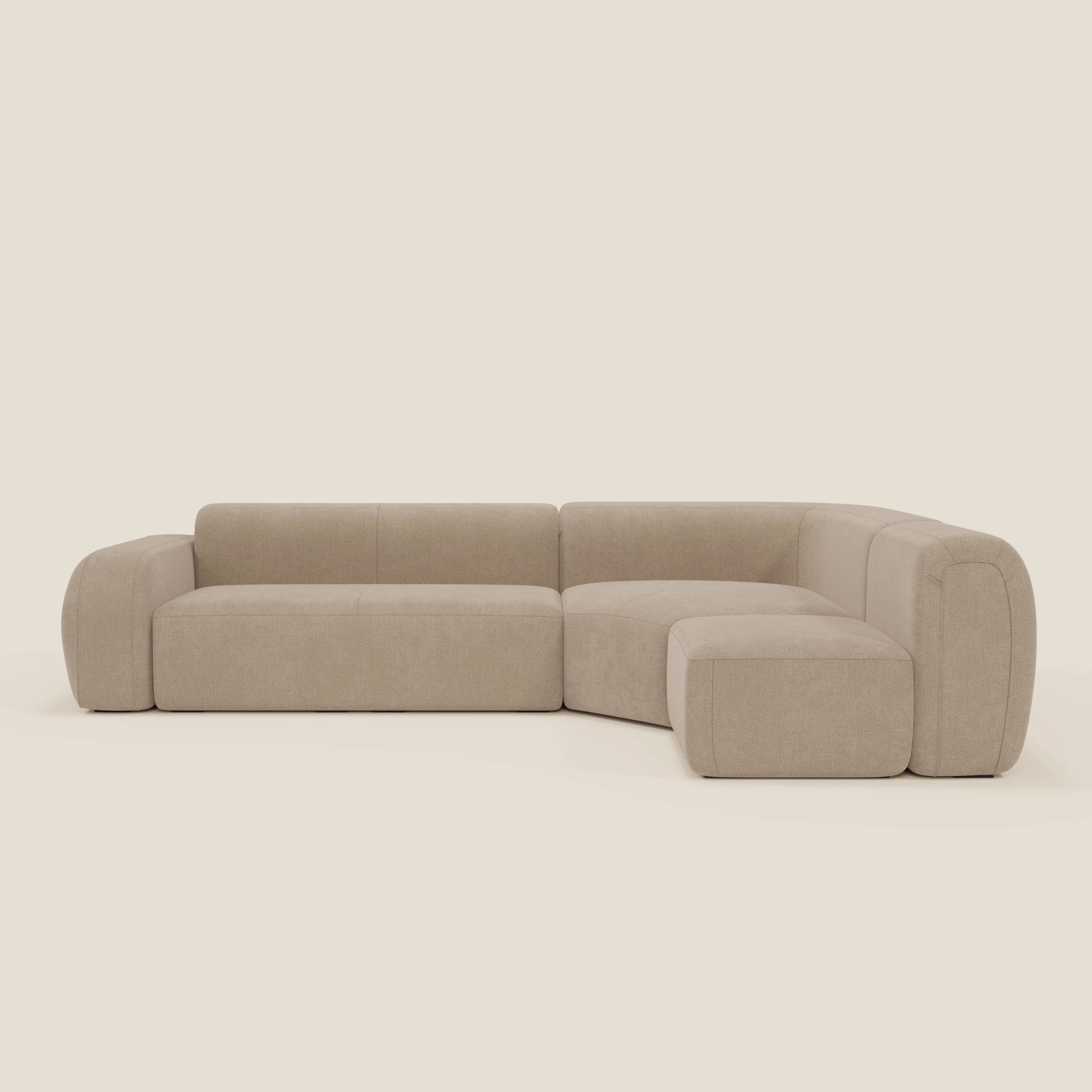 Il divano BonBon angolare componibile e modulare di Divani.Store è caratterizzato da braccioli e schienali bassi e arrotondati con tessuto T23 beige chiaro e antimacchia per un look morbido e moderno e un design minimalista.