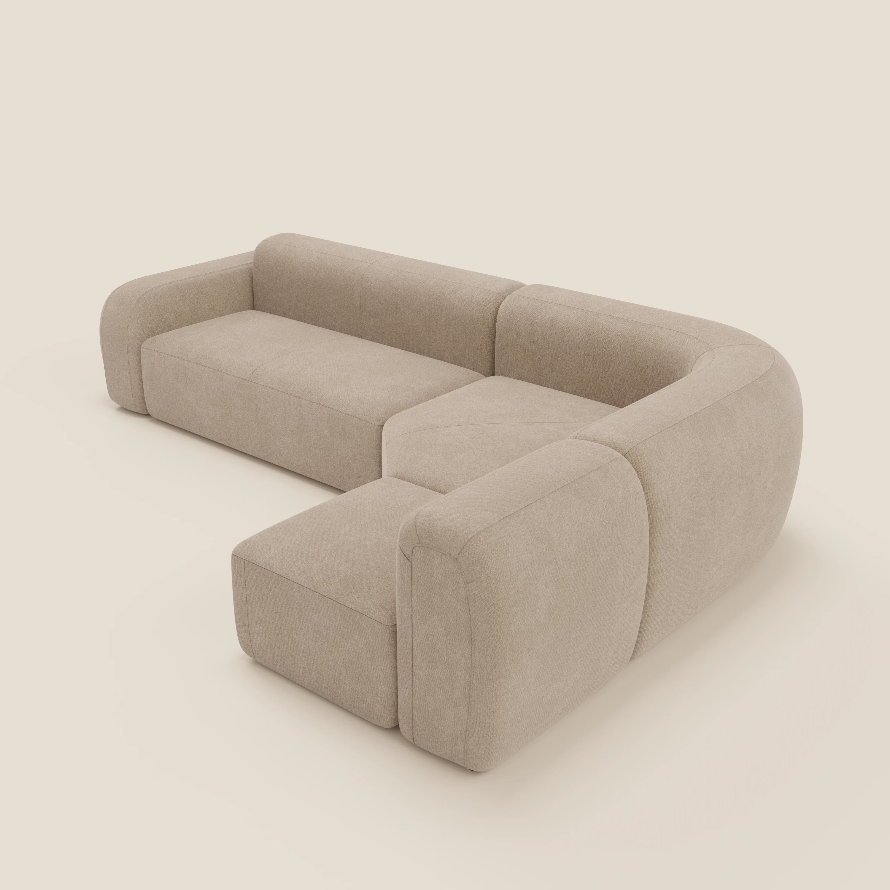 Il divano angolare componibile e modulare BonBon di Divani.Store, in tessuto smacchiabile T23 beige, è caratterizzato da una moderna forma a L con bordi arrotondati e cuscini morbidi in un design minimalista e senza gambe.