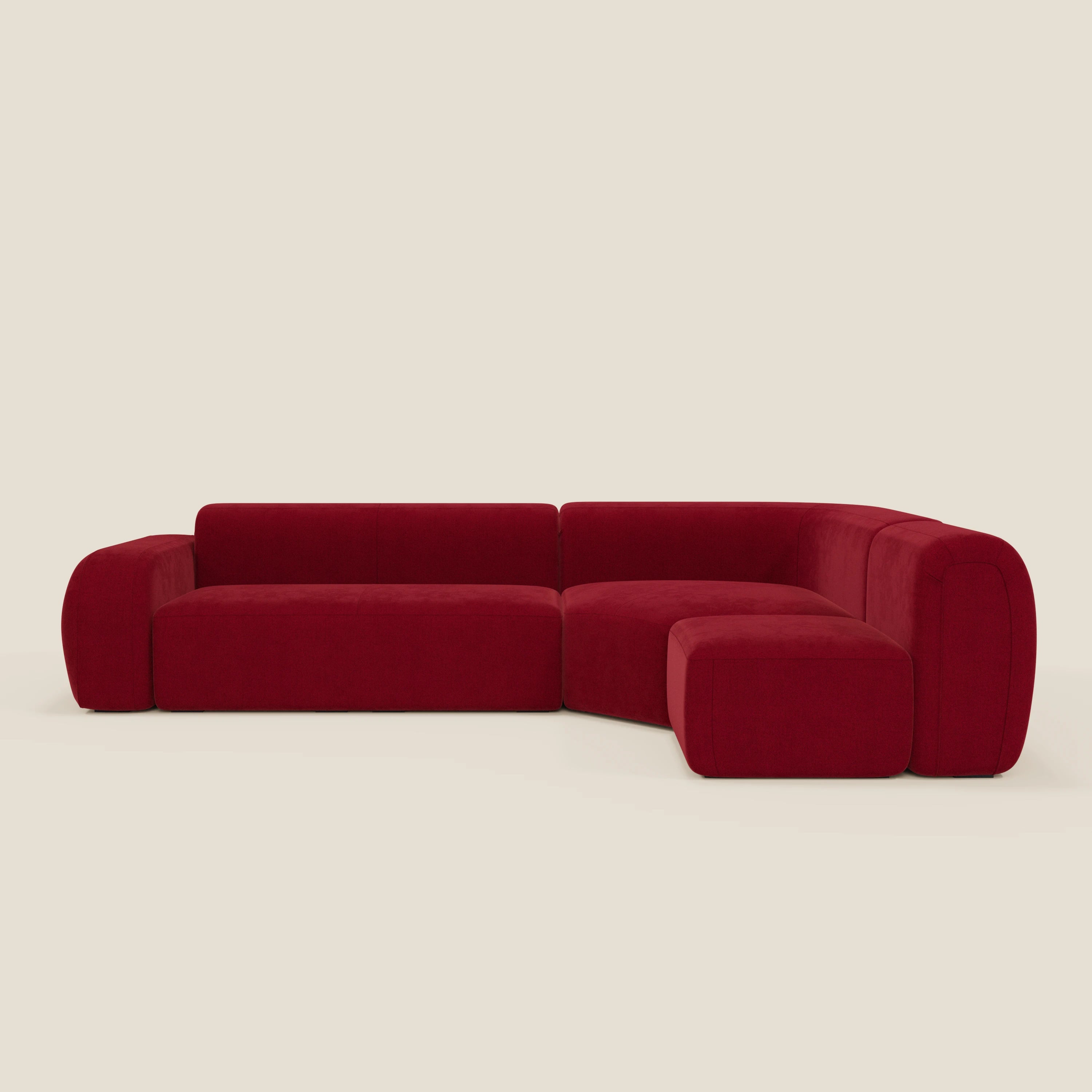 Il divano angolare componibile e modulare BonBon di Divani.Store, in tessuto smacchiabile T23 bordeaux, è caratterizzato da un'imbottitura morbida, bordi bassi e arrotondati e un design modulare a L per un comfort moderno su uno sfondo beige.