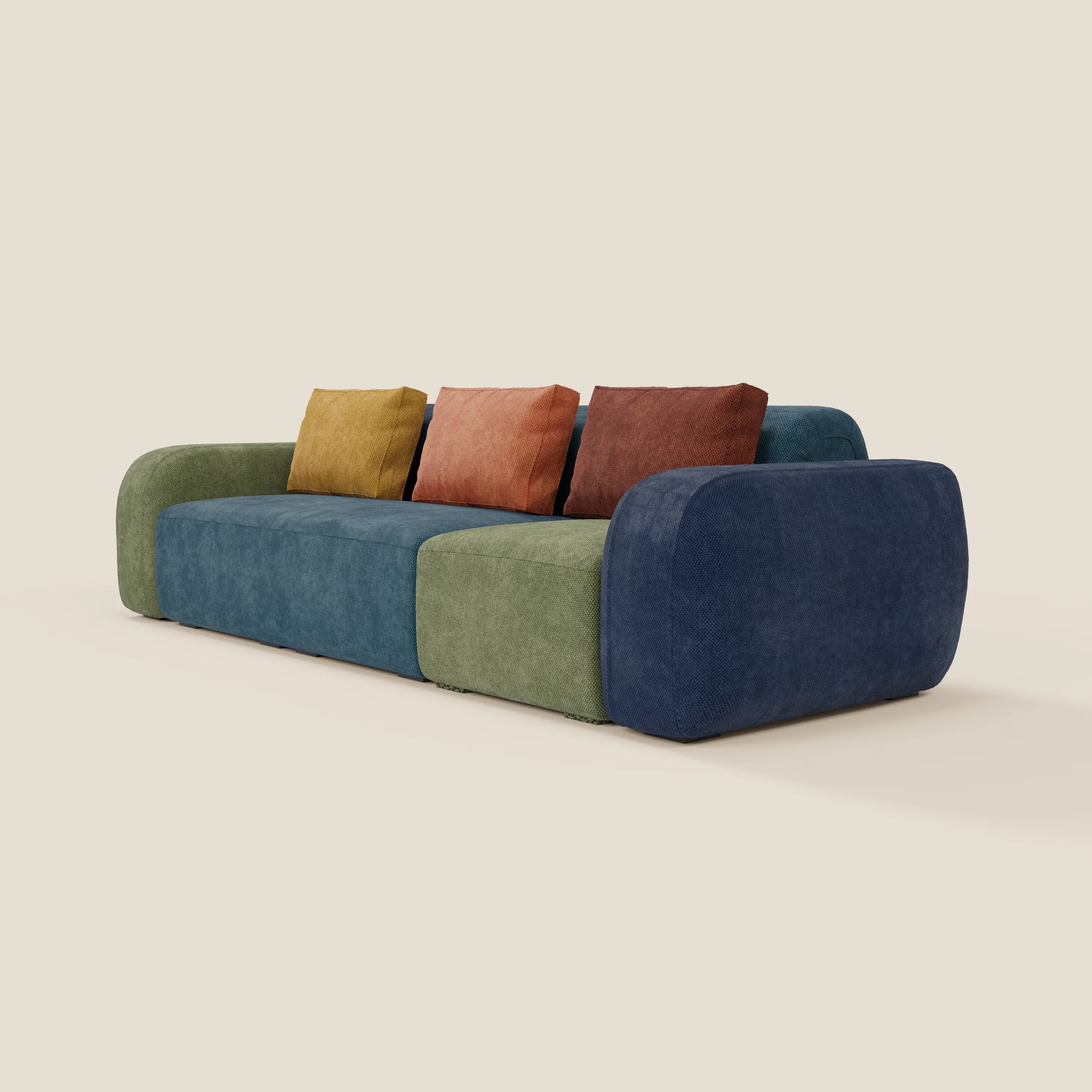 Il divano componibile BonBon 4 posti - edizione Grande Fratello di Divani.Store è caratterizzato da spigoli arrotondati, sedute in verde scuro, blu, verde oliva e quattro cuscini quadrati in giallo, ruggine e due arancioni: un prodotto italiano che spicca su qualsiasi sfondo color crema.