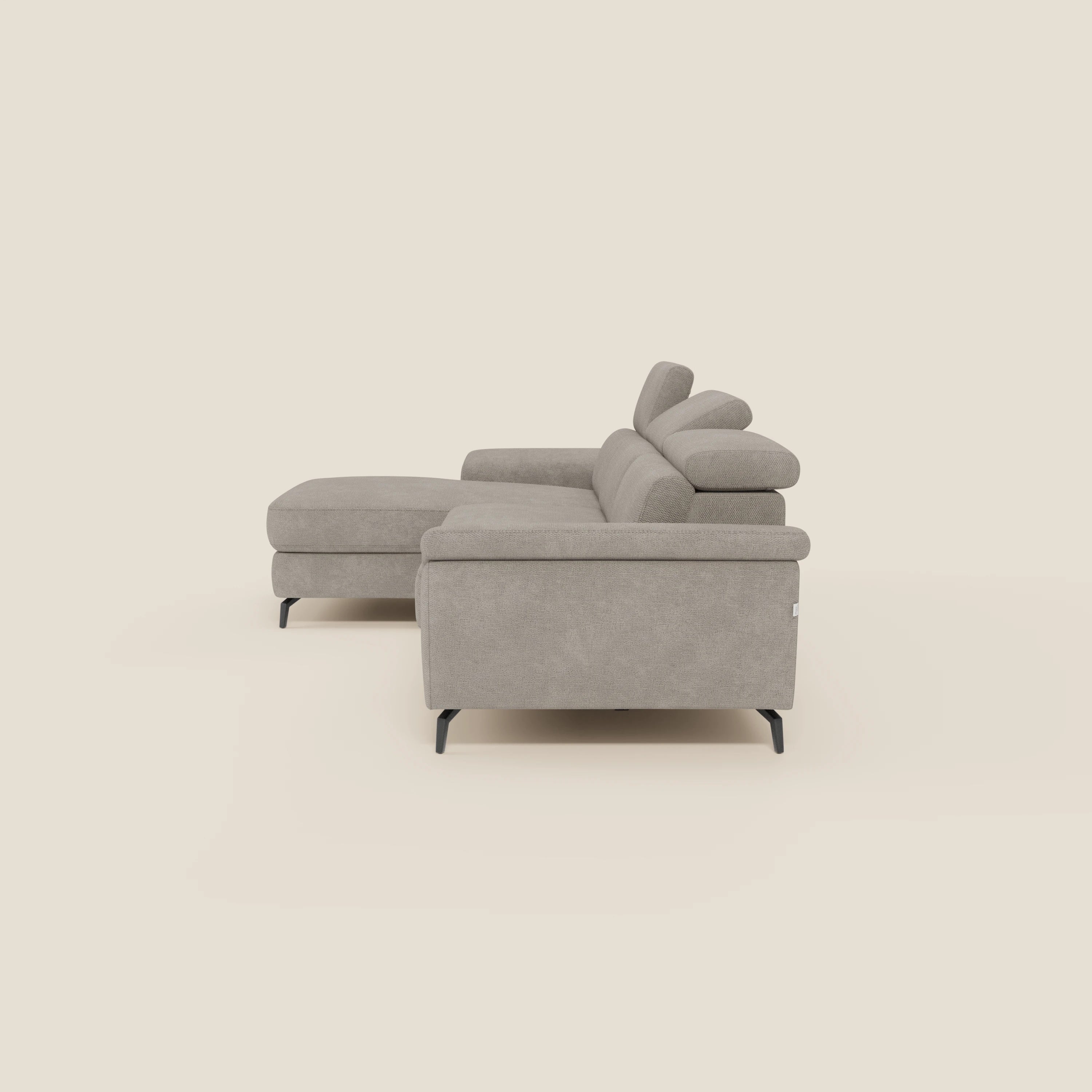 Il divano estraibile Estro di Divani.Store, in tessuto impermeabile T14 tortora, è caratterizzato da una chaise-longue a sinistra, poggiatesta reclinabili e gambe in metallo nero, viste di lato su sfondo beige.