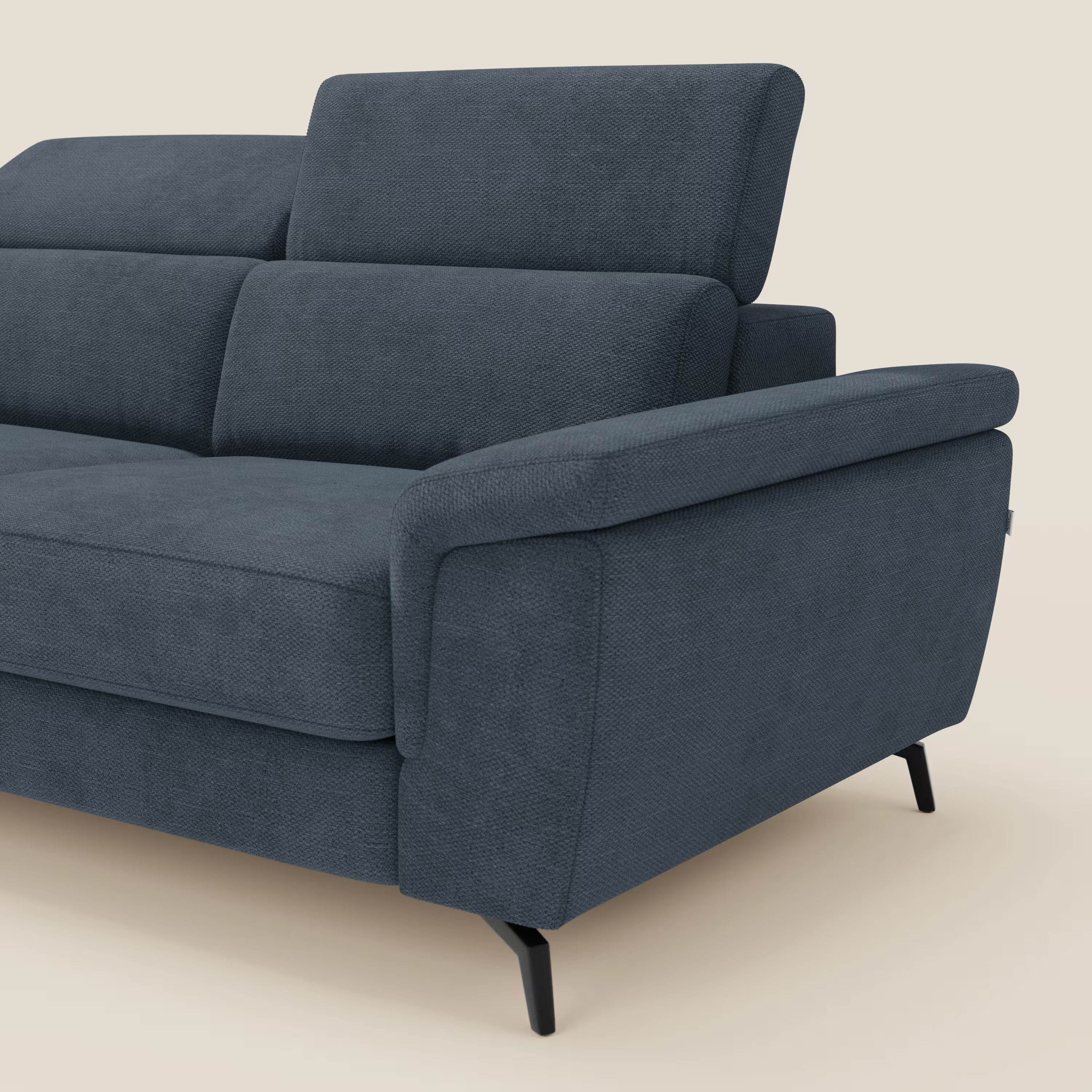 L'Estro Divano 3 posti con pouf estraibile di Divani.Store, in tessuto impermeabile T14 blu con poggiatesta reclinabili, è mostrato di lato su sfondo beige chiaro, evidenziando la seduta e lo schienale.