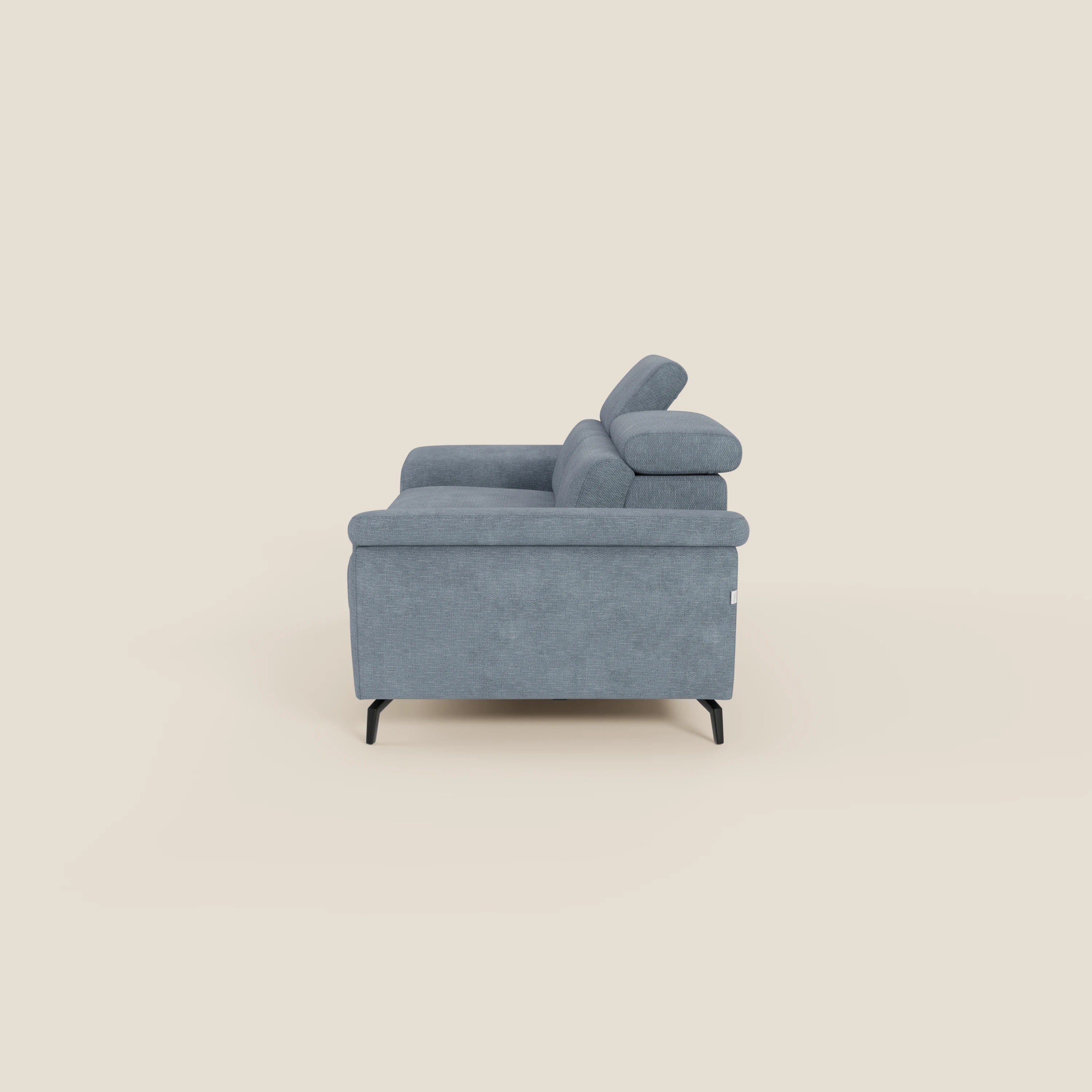 Estro Divano 3 posti con pouf estraibile di Divani.Store, presentato in tessuto impermeabile T14 azzurro, è caratterizzato da ampie sedute, braccioli spessi, poggiatesta regolabili, funzione chaise longue e gambe sottili nere su sfondo beige.