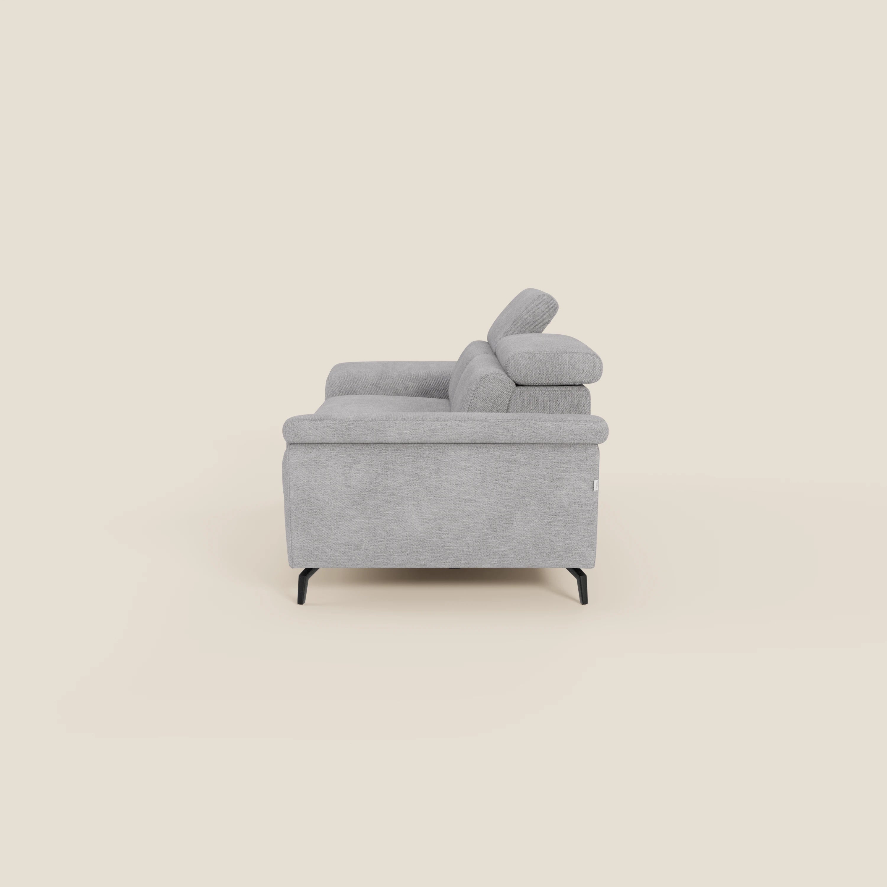 Estro Divano 3 posti con pouf estraibile di Divani.Store è dotato di poggiatesta reclinabili, gambe nere e rivestimento in tessuto impermeabile T14 grigio chiaro per una facile pulizia.