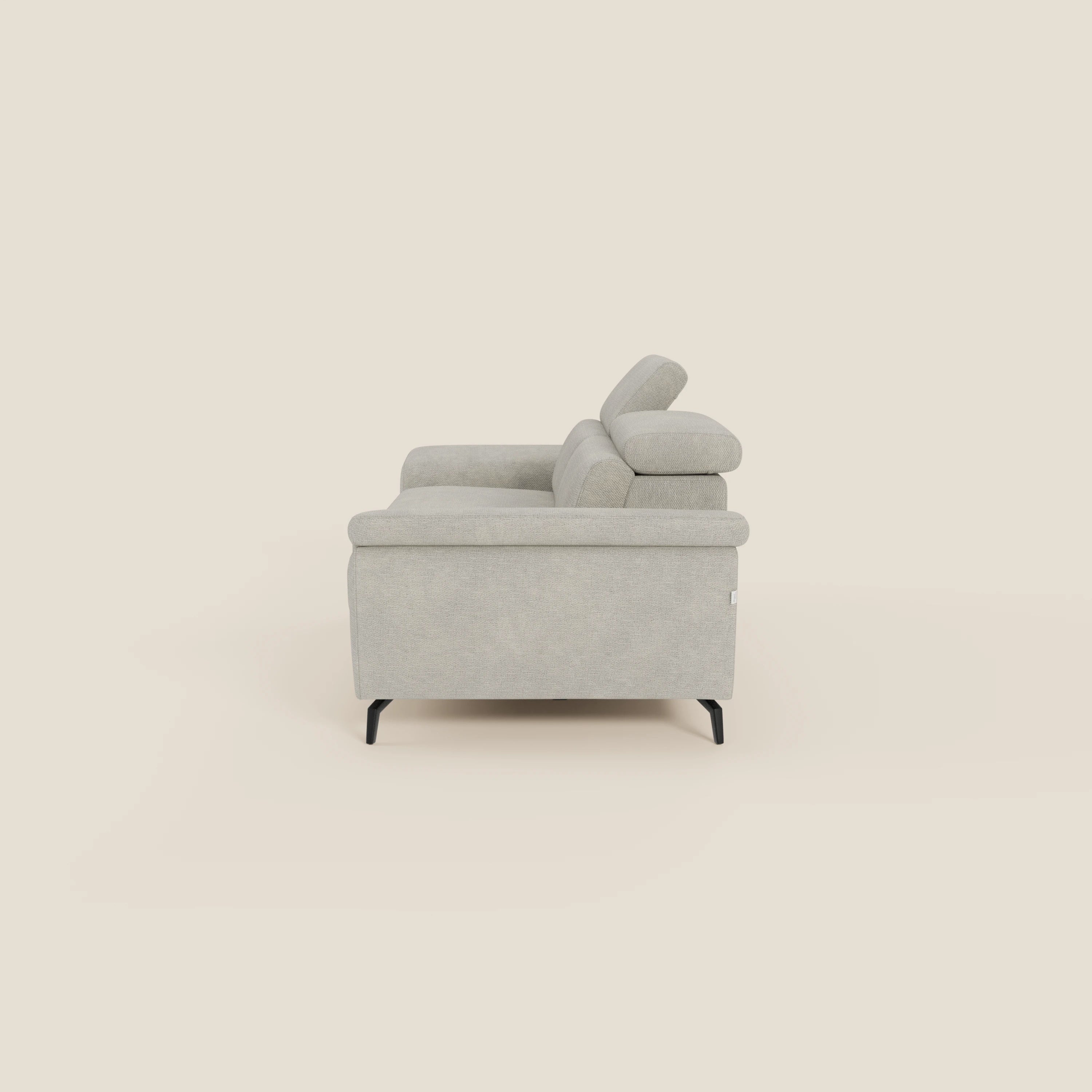 L'Estro Divano 3 posti con pouf estraibile di Divani.Store, in tessuto impermeabile T14 panna, presenta poggiatesta reclinabili, ampie sedute e un design minimal contemporaneo su eleganti gambe nere.