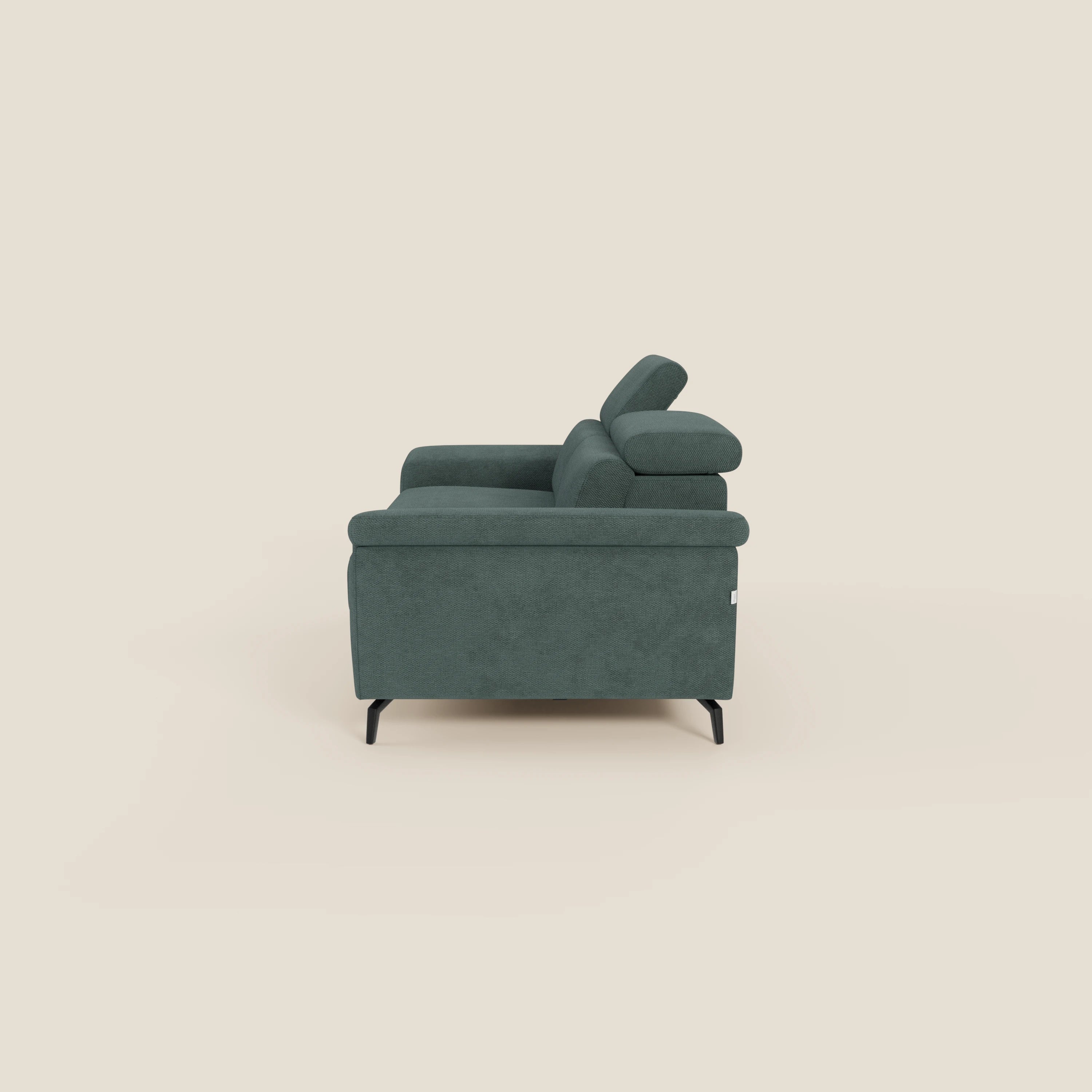 Vista laterale di Estro Divano 3 posti con pouf estraibile di Divani.Store, caratterizzato da poggiatesta reclinabili, cuscini morbidi e sottili gambe in metallo nero con tessuto impermeabile verde T14 su sfondo beige chiaro.