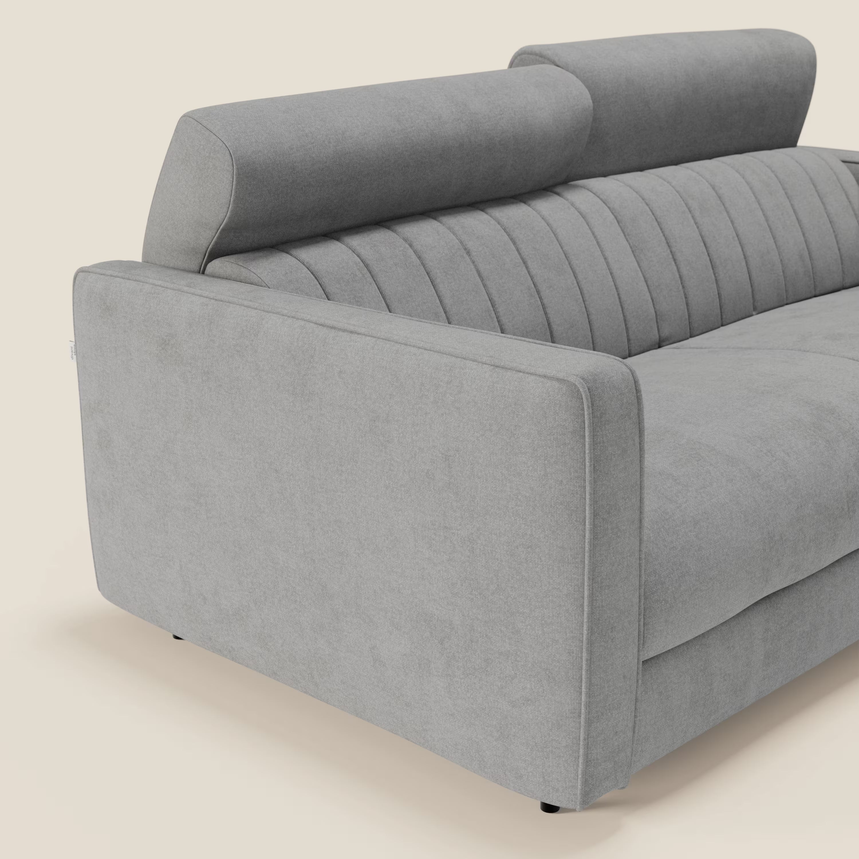 Il divano letto moderno Nivon di Divani.Store è caratterizzato da tessuto impermeabile T25 grigio chiaro, materasso H16 cm, schienale imbottito con ciuffi verticali, linee pulite, braccioli rigidi e poggiatesta regolabili su sfondo bianco sporco.