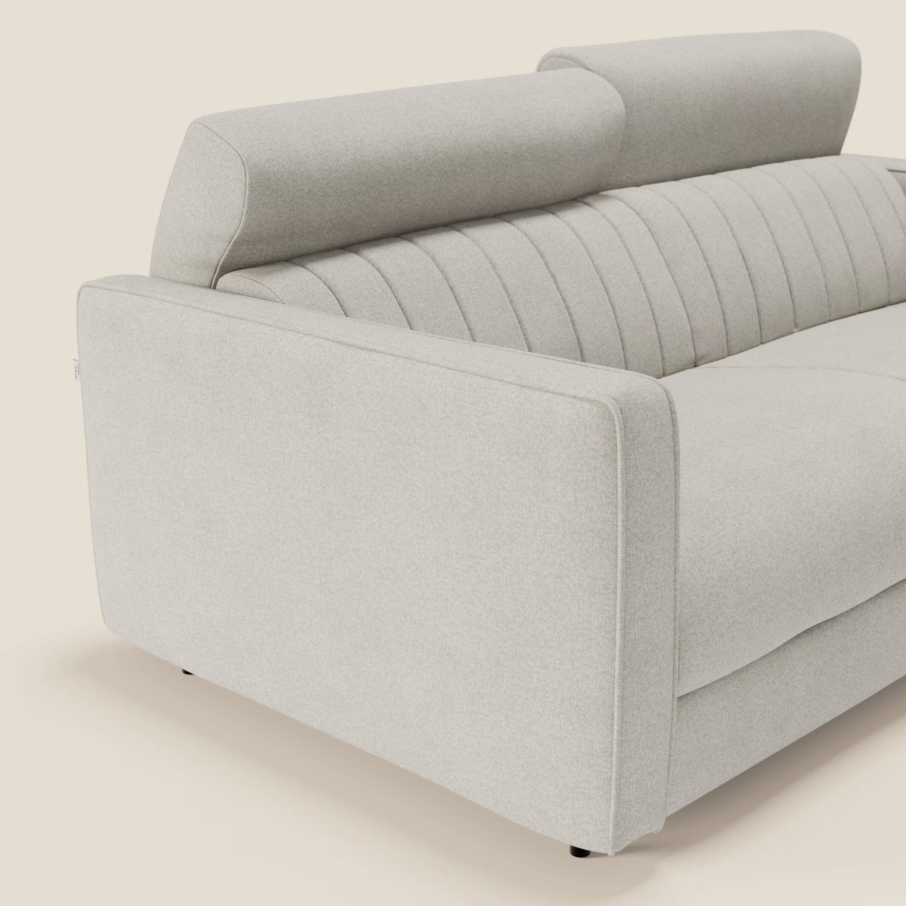 Una vista laterale ravvicinata del divano letto moderno Nivon di Divani.Store è caratterizzato da un morbido tessuto panna T25 impermeabile, sottili cuciture verticali e un poggiatesta regolabile, su uno sfondo semplice color crema. È visibile solo una parte del divano letto.