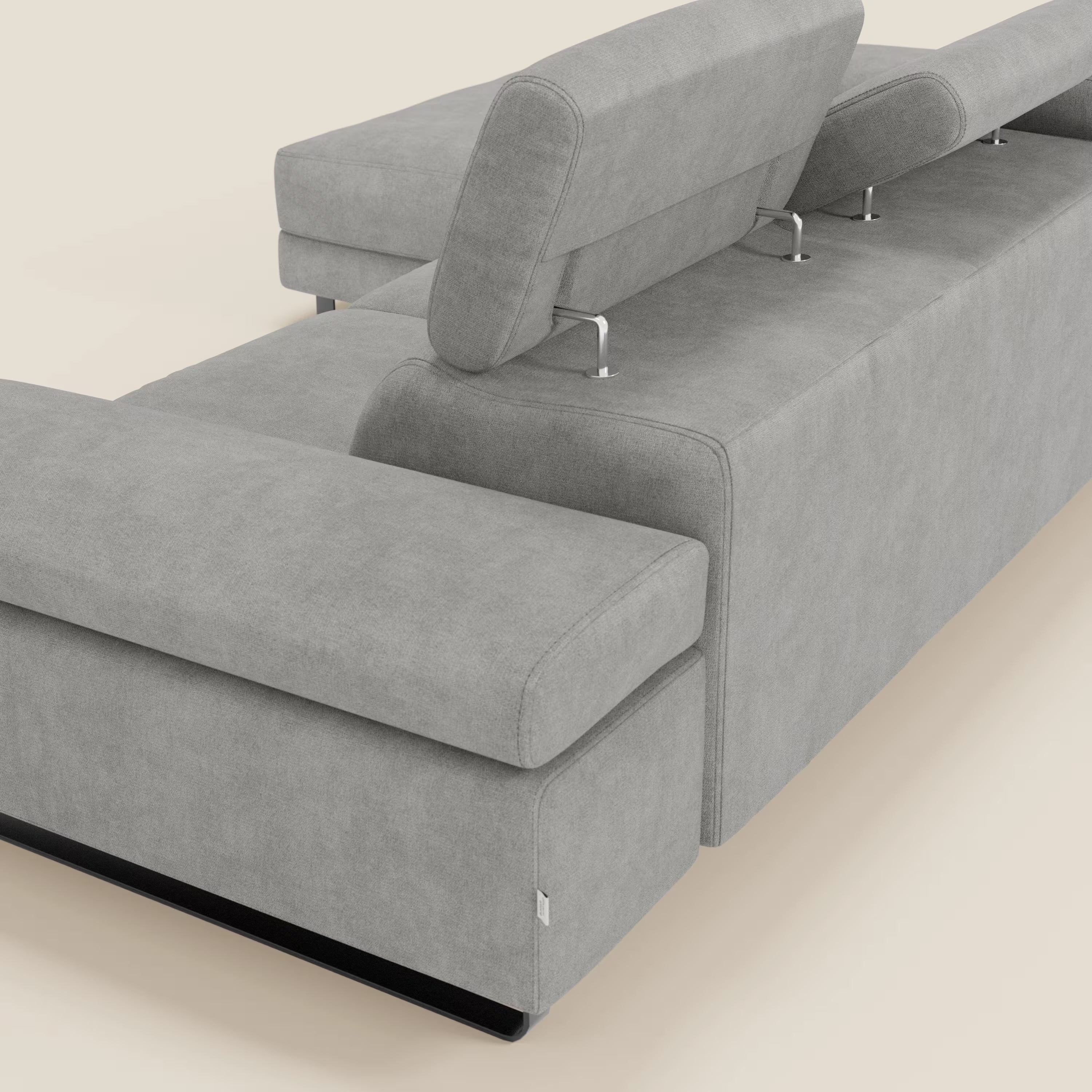 Un primo piano del divano angolare estraibile Zayana di Divani.Store mostra il tessuto impermeabile T02 grigio chiaro, i braccioli e i poggiatesta regolabili con supporti in metallo e le linee eleganti e minimaliste che ne evidenziano lo stile moderno.