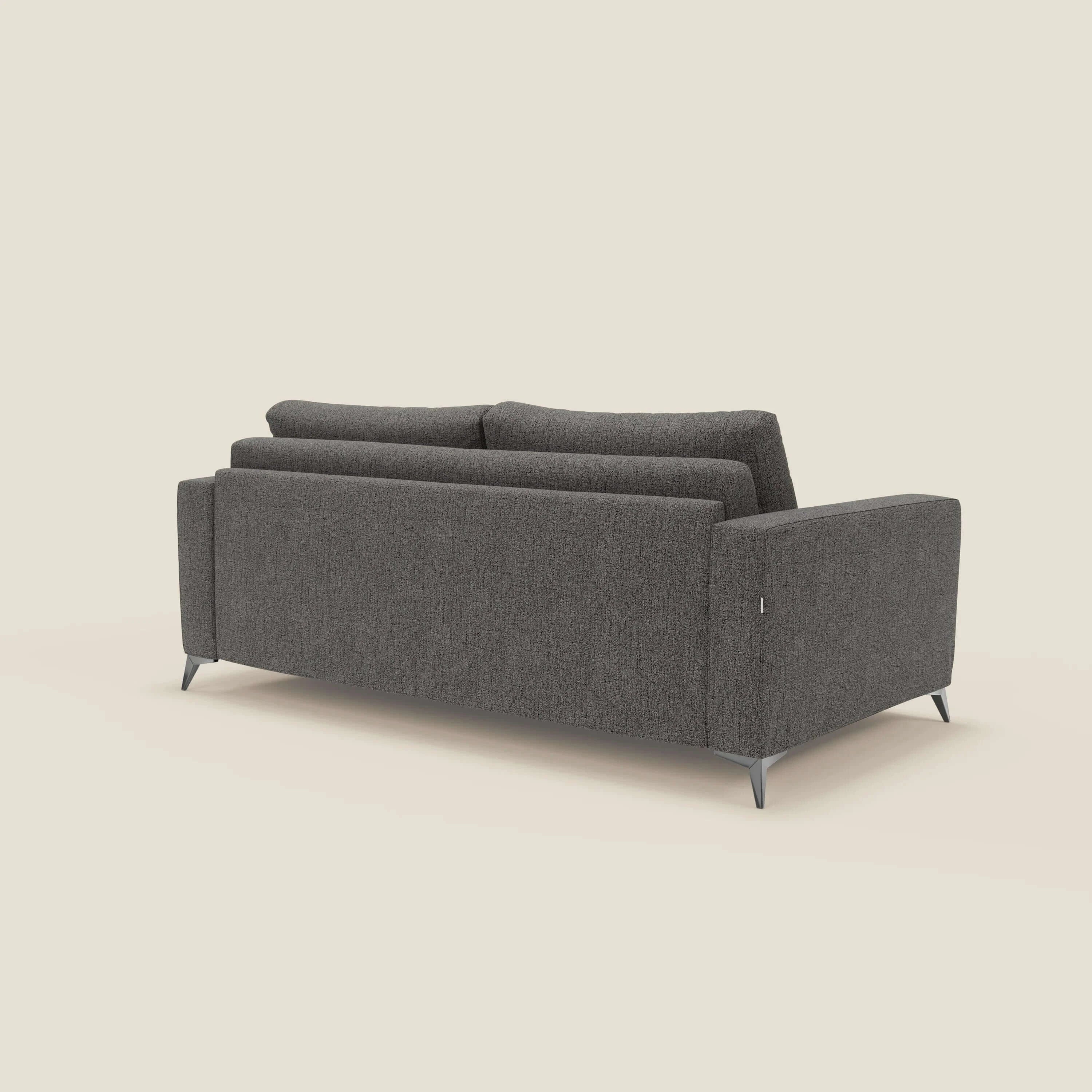 Il divano letto matrimoniale Alaya di Divani.Store è mostrato dal retro in posizione angolata. Il morbido tessuto impermeabile T03 antracite, le linee pulite, i braccioli squadrati e le sottili gambe angolari in metallo spiccano su uno sfondo beige chiaro.
