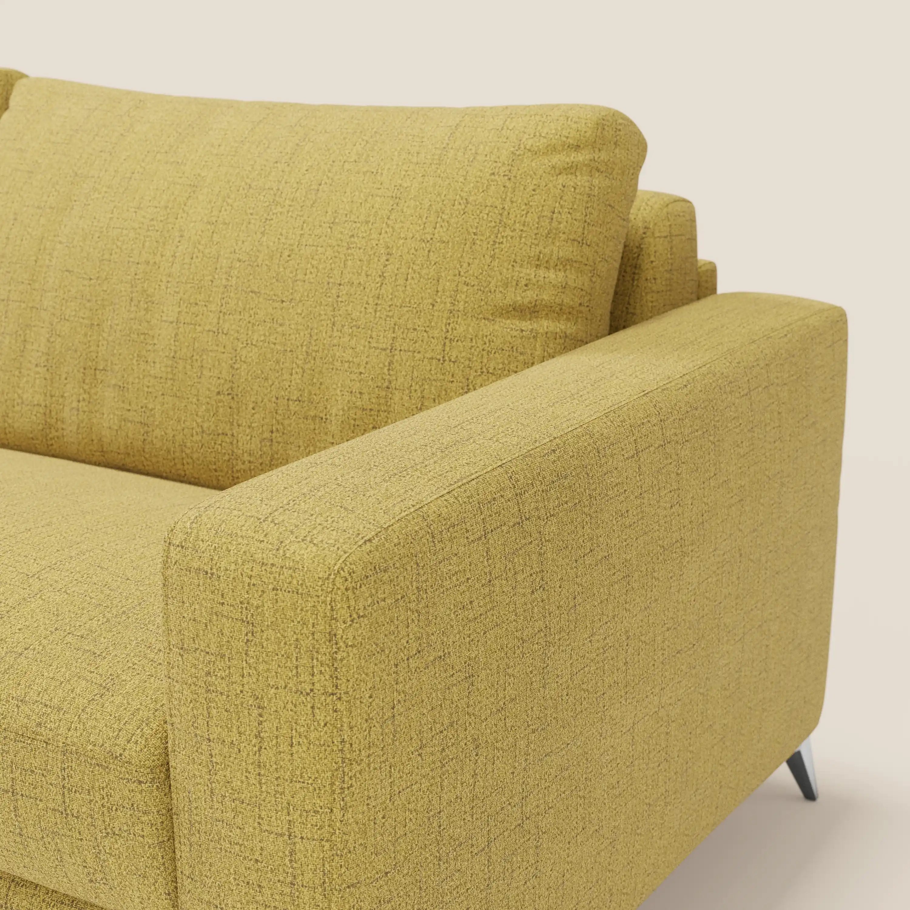 Primo piano del divano letto matrimoniale Alaya di Divani.Store, caratterizzato da morbidi cuscini in tessuto impermeabile giallo T03 e sottili gambe nere dal design minimale, su sfondo bianco sporco.