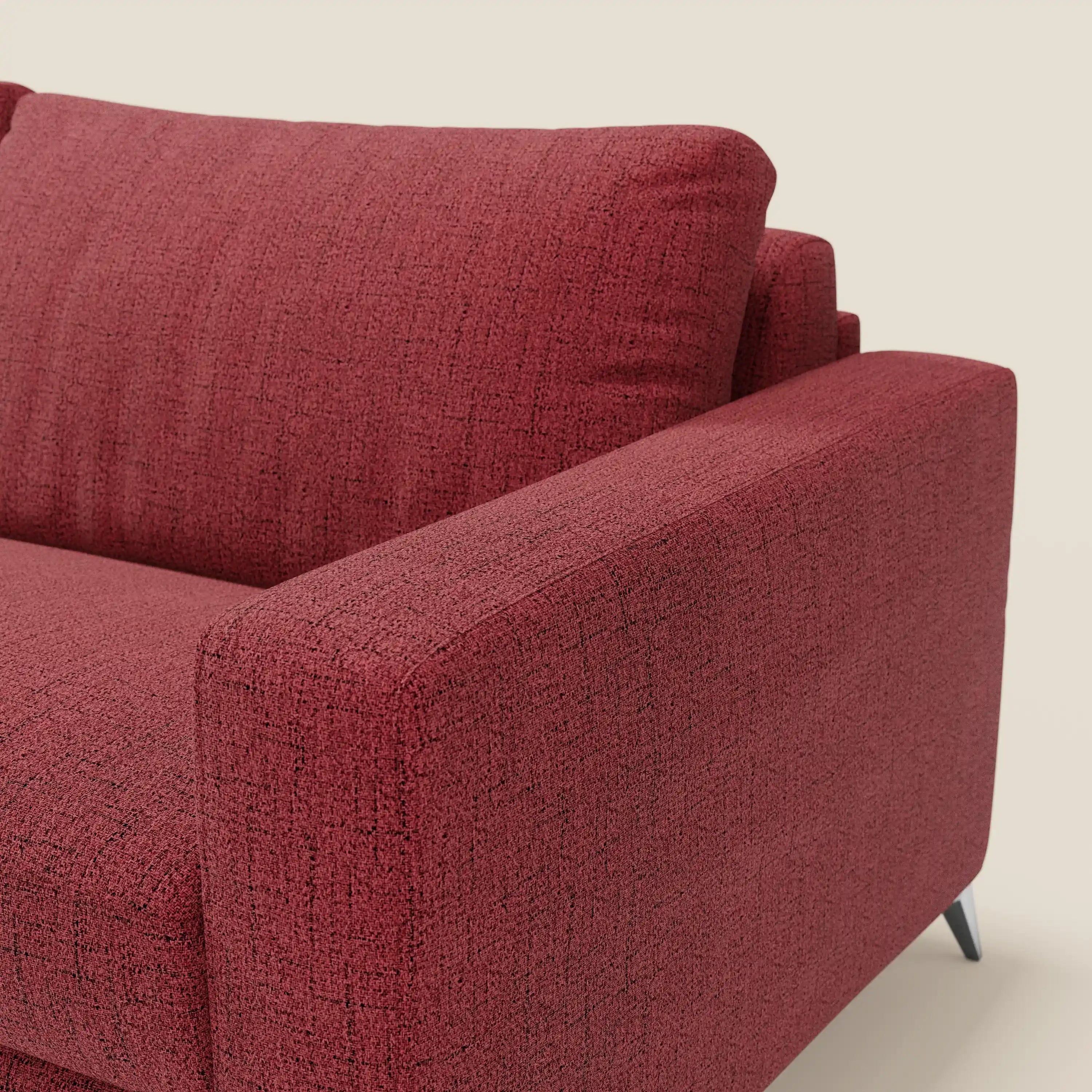 Un primo piano del letto matrimoniale Alaya Divano di Divani.Store mostra il tessuto impermeabile rosso T03, i morbidi cuscini e il design minimalista con bracciolo, seduta e schienale destri su corte gambe nere su uno sfondo semplice.