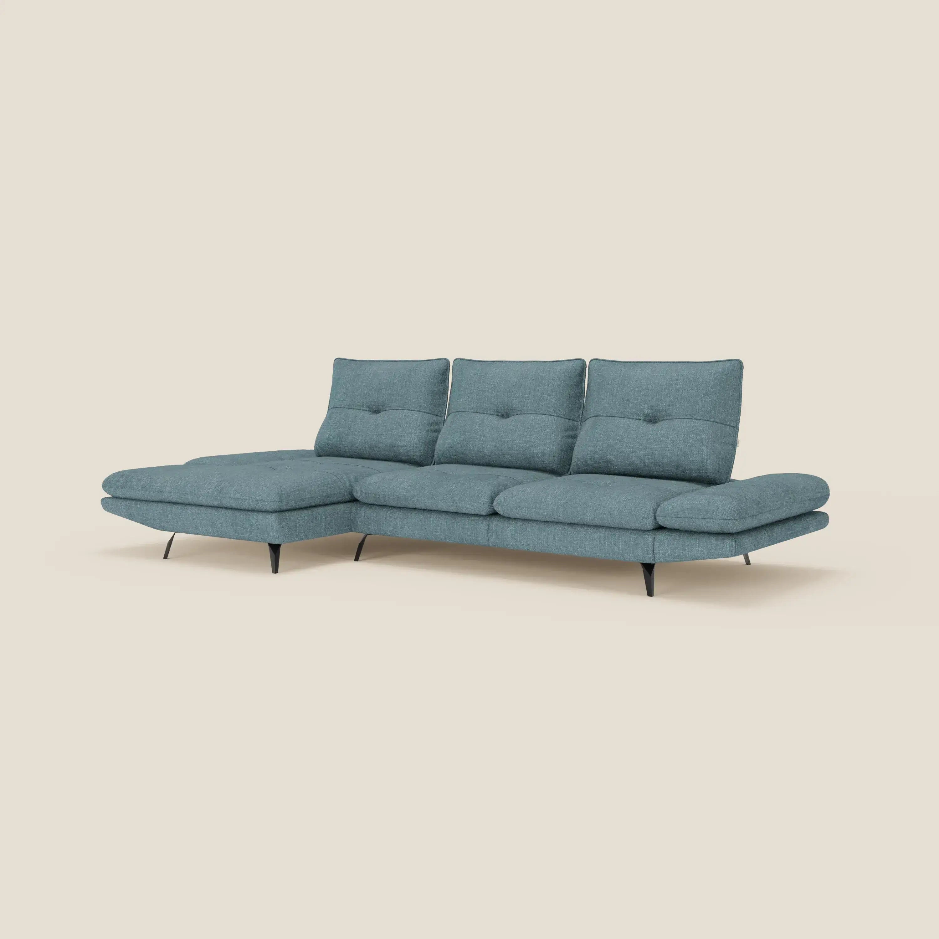 Ardex Divano con penisola di Divani.Store è caratterizzato da un elegante tessuto impermeabile T06 azzurro, tre schienali scorrevoli, braccioli regolabili e sottili gambe in metallo nero. Il divano moderno include una chaise sul lato sinistro ed è inserito in un semplice sfondo color crema.