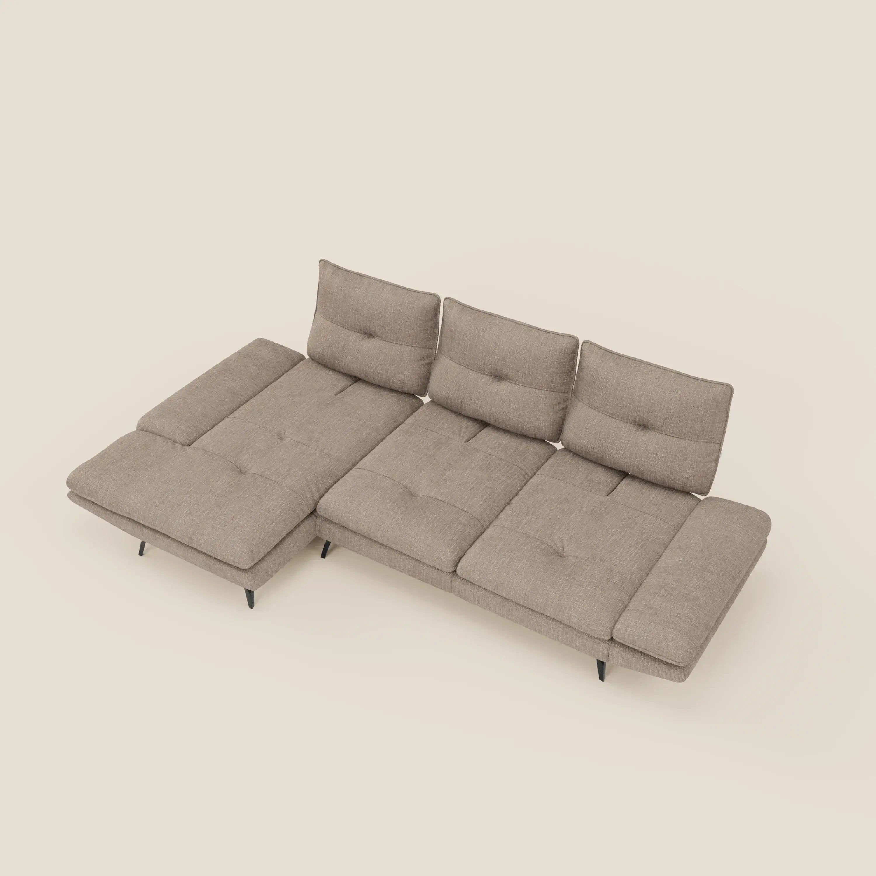 L'Ardex Divano con penisola di Divani.Store è caratterizzato da schienali traslanti, braccioli regolabili ed elegante tessuto impermeabile T06 tortora a forma di L con chaise longue, visto dall'alto su sfondo bianco sporco.