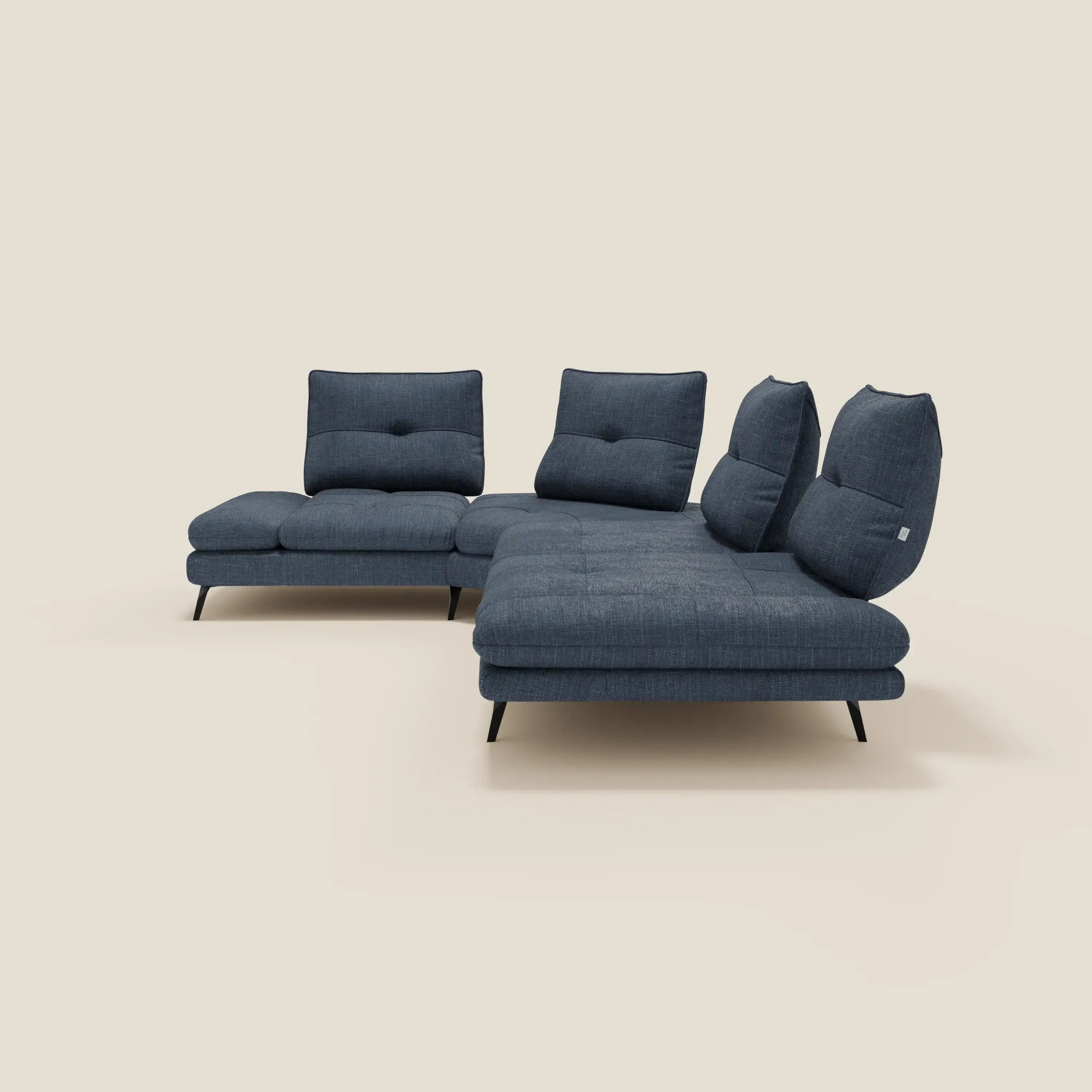 L'Ardex Divano Angolare di Divani.Store, in elegante tessuto impermeabile blu T06, è caratterizzato da tre schienali scorrevoli, un bracciolo regolabile e una chaise longue sul lato destro, con cuscini trapuntati e gambe nere angolate su sfondo beige.
